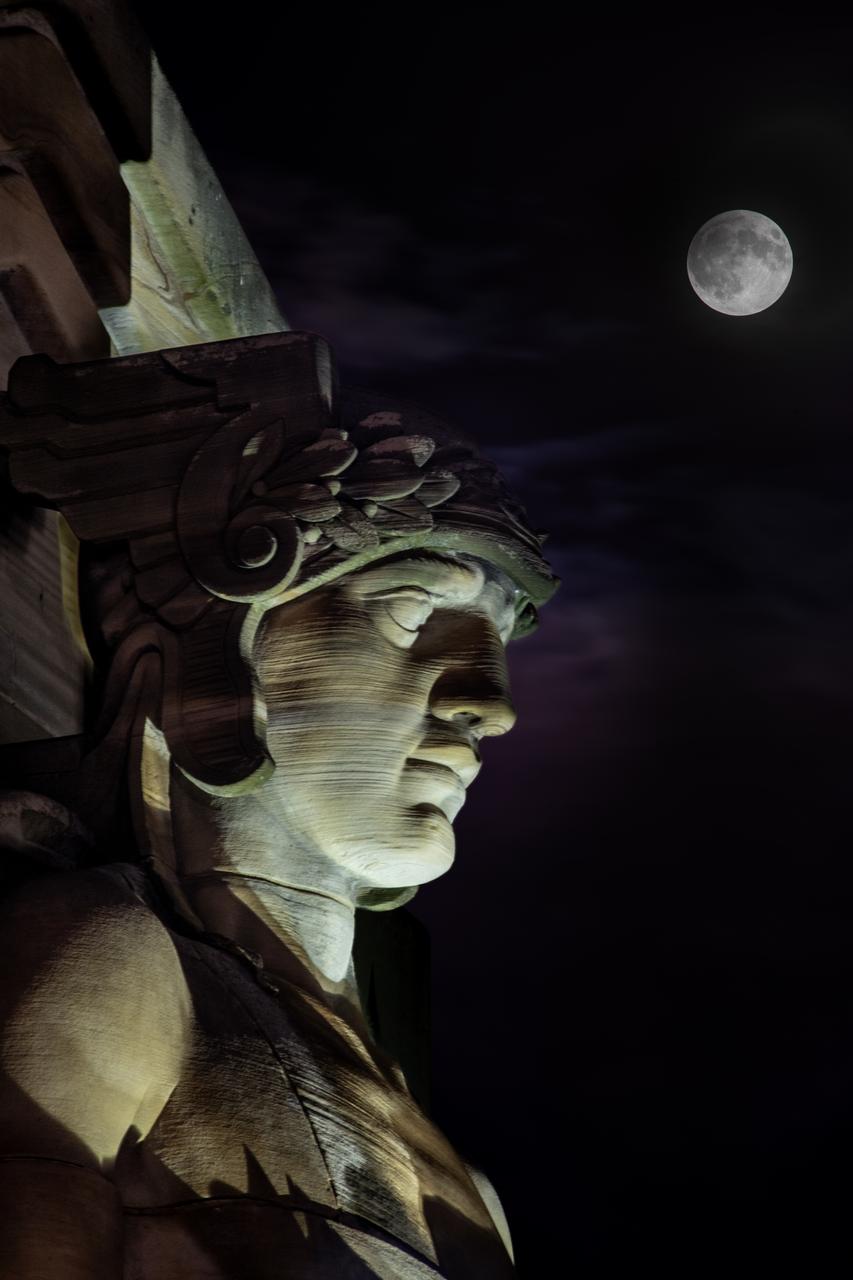 Guardians of Traffic Statue in Cleveland, OH watches over the Supermoon that was visible on September 17th, 2024. On this day, the full moon was a partial Lunar Eclipse; a Supermoon; and a Harvest Moon. Photo Credit: (NASA/Sara Lowthian-Hanna)