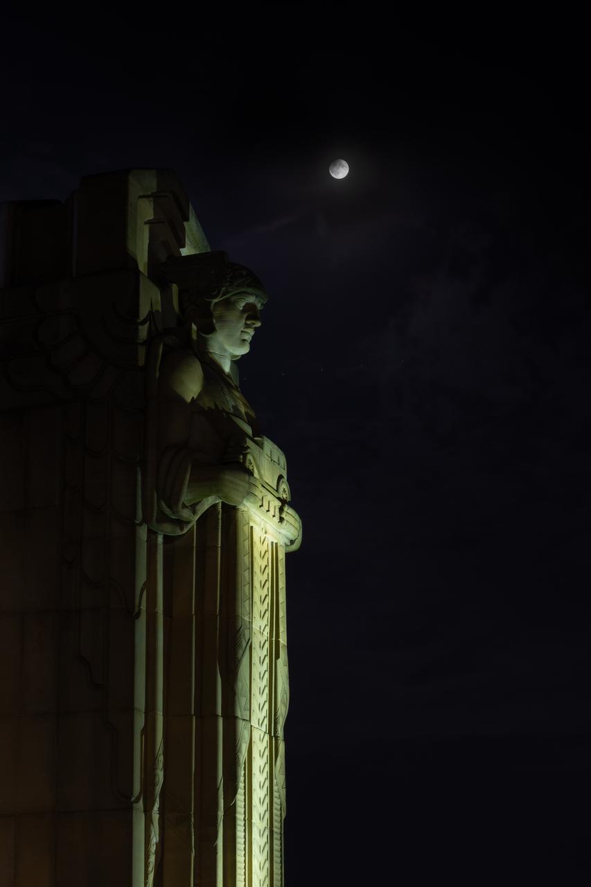 Guardians of Traffic Statue in Cleveland, OH in front of the Supermoon that was visible on September 17th, 2024. On this day, the full moon was a partial lunar eclipse; a supermoon; and a harvest moon. Photo Credit: (NASA/Sara Lowthian-Hanna)