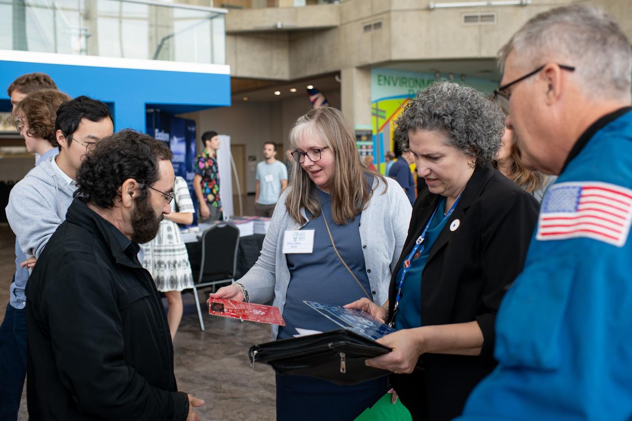 Philip Lubin from Team H.E.L.P.S. (High Efficiency Long-Range Power Solution) explains his project to Mary Wadel, Kirsten Ellenbogen and Stephen Bowen.  NASA has awarded a total of $1.5 million to two U.S. teams for their novel technology solutions addressing energy distribution, management, and storage as part of the agency’s Watts on the Moon Challenge. The innovations from this challenge aim to support NASA’s Artemis missions, which will establish long-term human presence on the Moon.  This two-phase competition has challenged U.S. innovators to develop breakthrough power transmission and energy storage technologies that could enable long-duration Moon missions to advance the nation’s lunar exploration goals. The final phase of the challenge concluded with a technology showcase and winners’ announcement ceremony Friday at Great Lakes Science Center, home of the visitor center for NASA’s Glenn Research Center in Cleveland.  Team H.E.L.P.S. (High Efficiency Long-Range Power Solution) from The University of California, Santa Barbara won the $1 million grand prize in NASA’s Watts on the Moon Challenge. Their team developed a low-mass, high efficiency cable and featured energy storage batteries on both ends of their power transmission and energy storage system.  Second prize ($500,000): Orbital Mining Corporation of Golden, Colorado Photo Credit: (NASA/Sara Lowthian-Hanna)