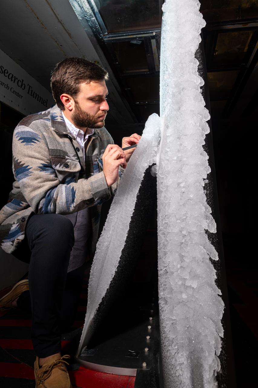 Thomas Ozoroski, an Icing Researcher, is shown documenting ice accretion on the leading edge of the next-generation Transonic Truss-Braced Wing design at NASA Glenn's Icing Research Center. This critical research will help understand icing effects for future, high-lift, ultra-efficient aircraft. Photo Credit: (NASA/Jordan Salkin)