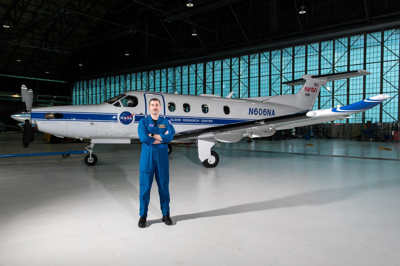 Jeremy Johnson, a research pilot and aviation safety officer, poses in front of a PC-12 aircraft inside the hangar at NASA’s Glenn Research Center in Cleveland on Thursday, April 17, 2025. Johnson flies NASA planes to support important scientific research and testing, working with researchers to plan and carry out flights that will get them the data they need while ensuring safety.
