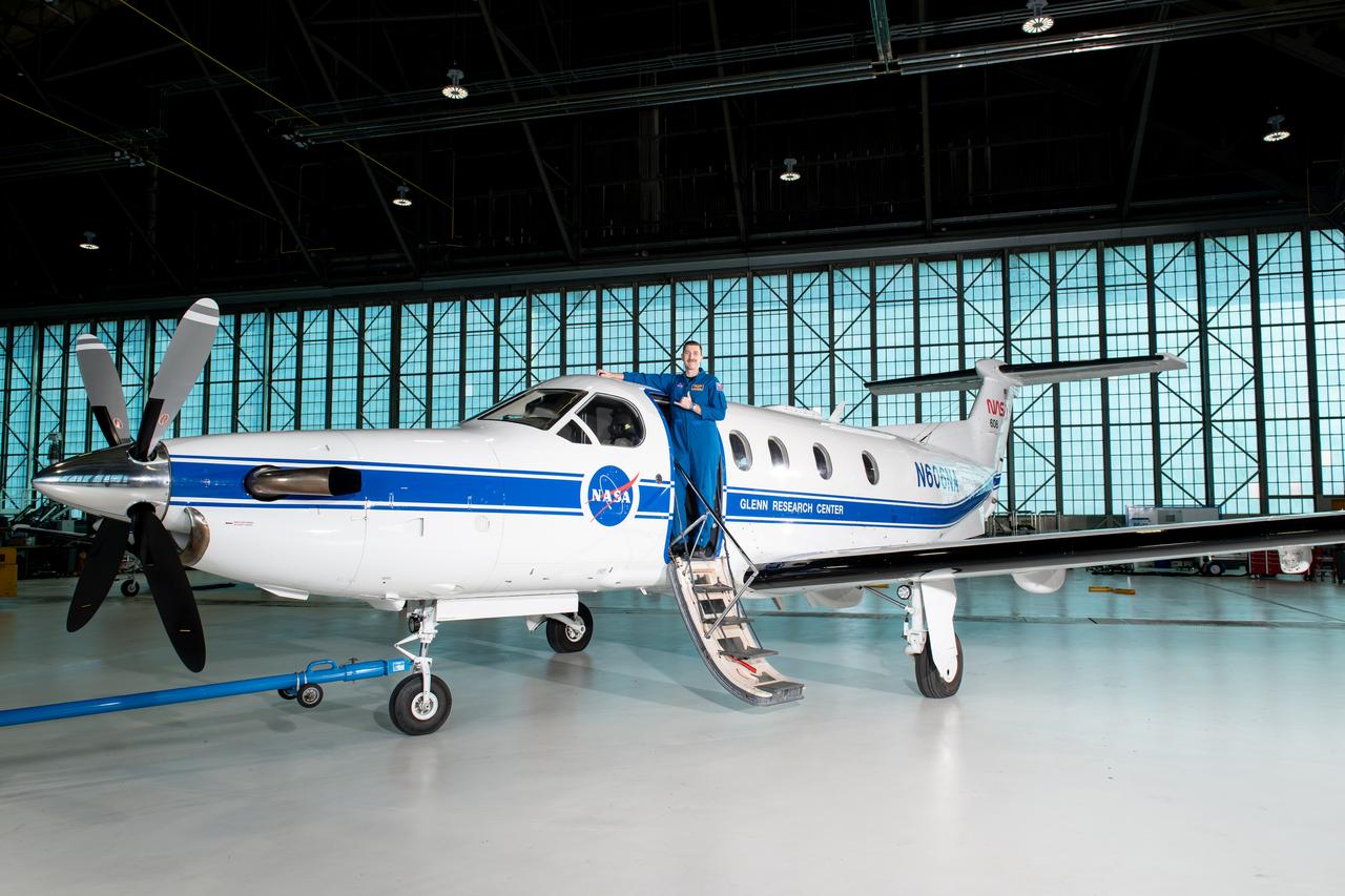 Jeremy Johnson, a research pilot and aviation safety officer, poses in front of a PC-12 aircraft inside the hangar at NASA’s Glenn Research Center in Cleveland on Thursday, April 17, 2025. Johnson flies NASA planes to support important scientific research and testing, working with researchers to plan and carry out flights that will get them the data they need while ensuring safety.