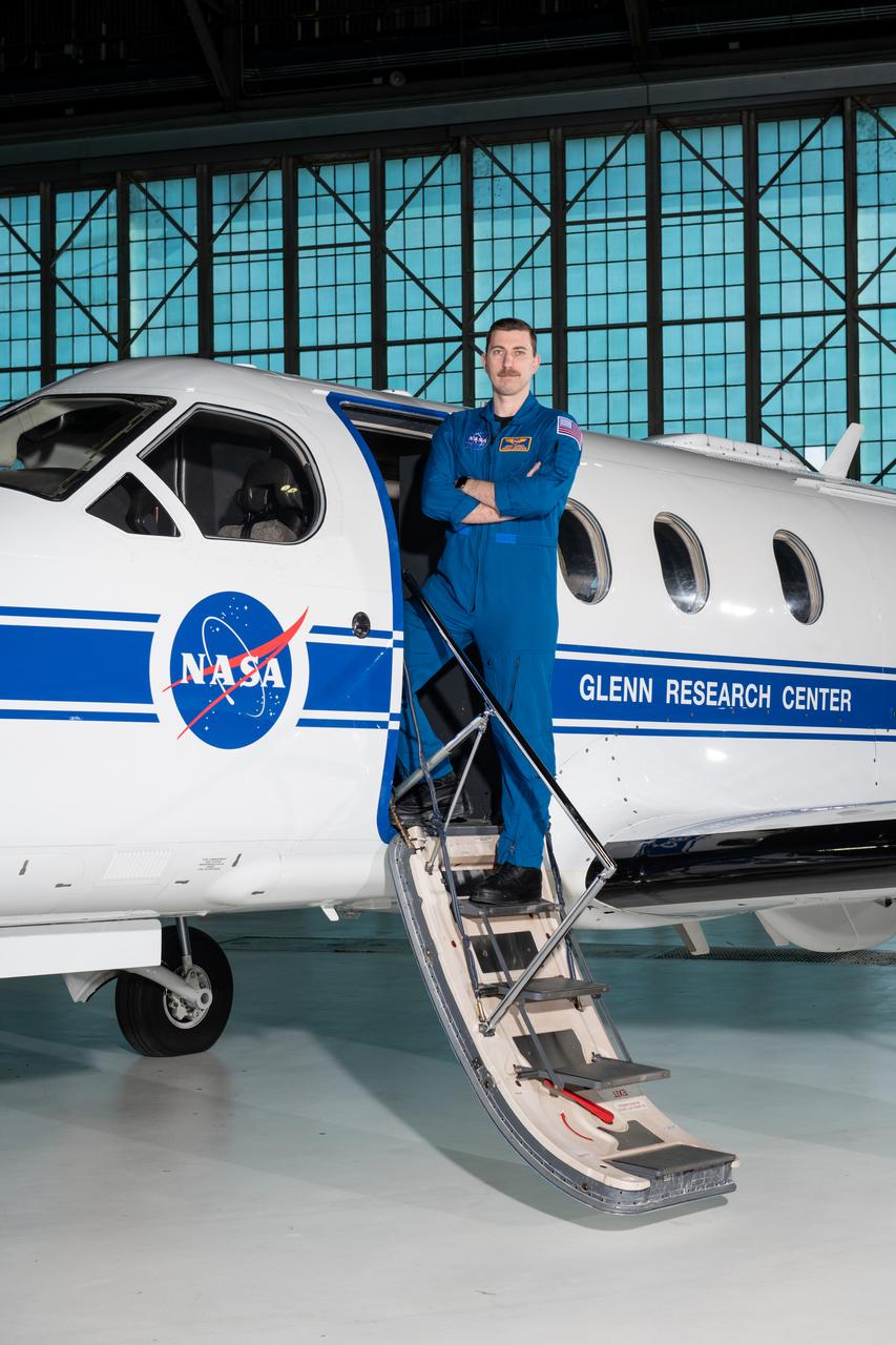 Jeremy Johnson, a research pilot and aviation safety officer, poses in front of a PC-12 aircraft inside the hangar at NASA’s Glenn Research Center in Cleveland on Thursday, April 17, 2025. Johnson flies NASA planes to support important scientific research and testing, working with researchers to plan and carry out flights that will get them the data they need while ensuring safety.