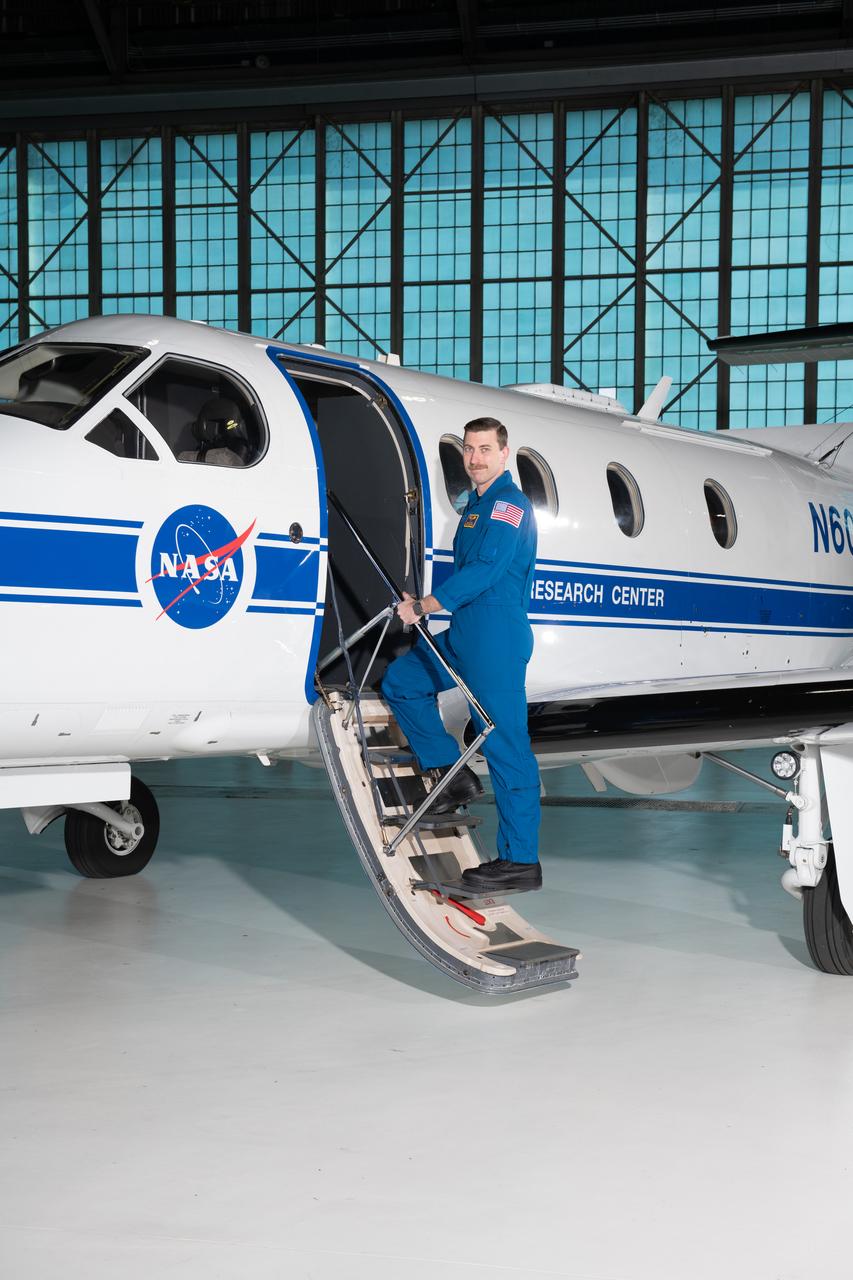 Jeremy Johnson, a research pilot and aviation safety officer, poses in front of a PC-12 aircraft inside the hangar at NASA’s Glenn Research Center in Cleveland on Thursday, April 17, 2025. Johnson flies NASA planes to support important scientific research and testing, working with researchers to plan and carry out flights that will get them the data they need while ensuring safety.