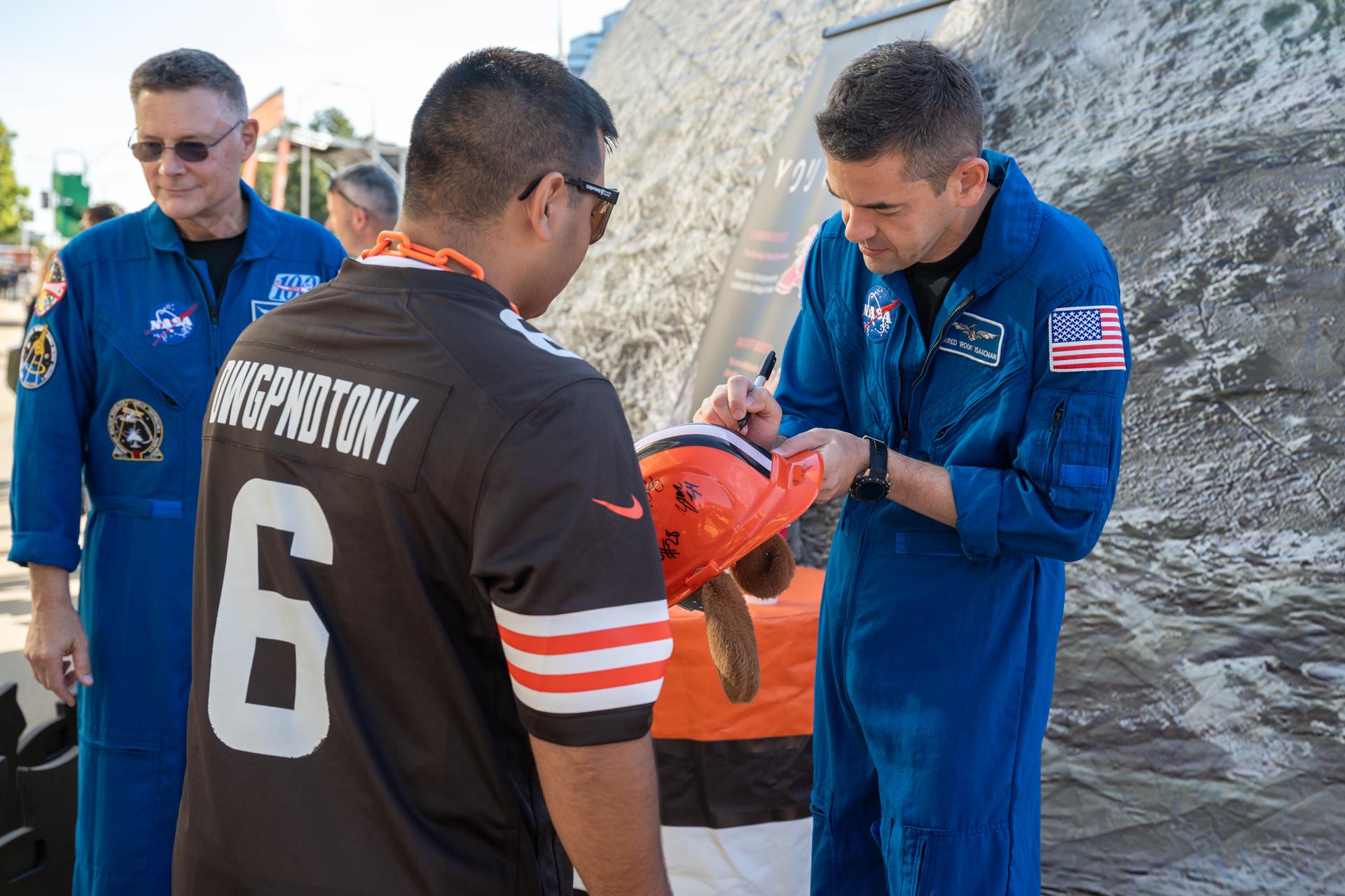 NASA Administrator Jared Isaacman signs a helmet for a Brown's fan at an NFL game between the Cleveland Browns and the Carolina Panthers at Huntington Bank Field, Sunday, September 27th, 2026, in Cleveland, Ohio. NASA’s engagement at NFL games is part of the agency’s Inspiration Tour, aimed at strengthening connections between NASA and its partners and showcasing innovation in air and space in the lead up to the MAX POWER aerospace technology expo and airshow at the agency’s Kennedy Space Center in early November. Photo Credit: (NASA/Jordan Cochran)