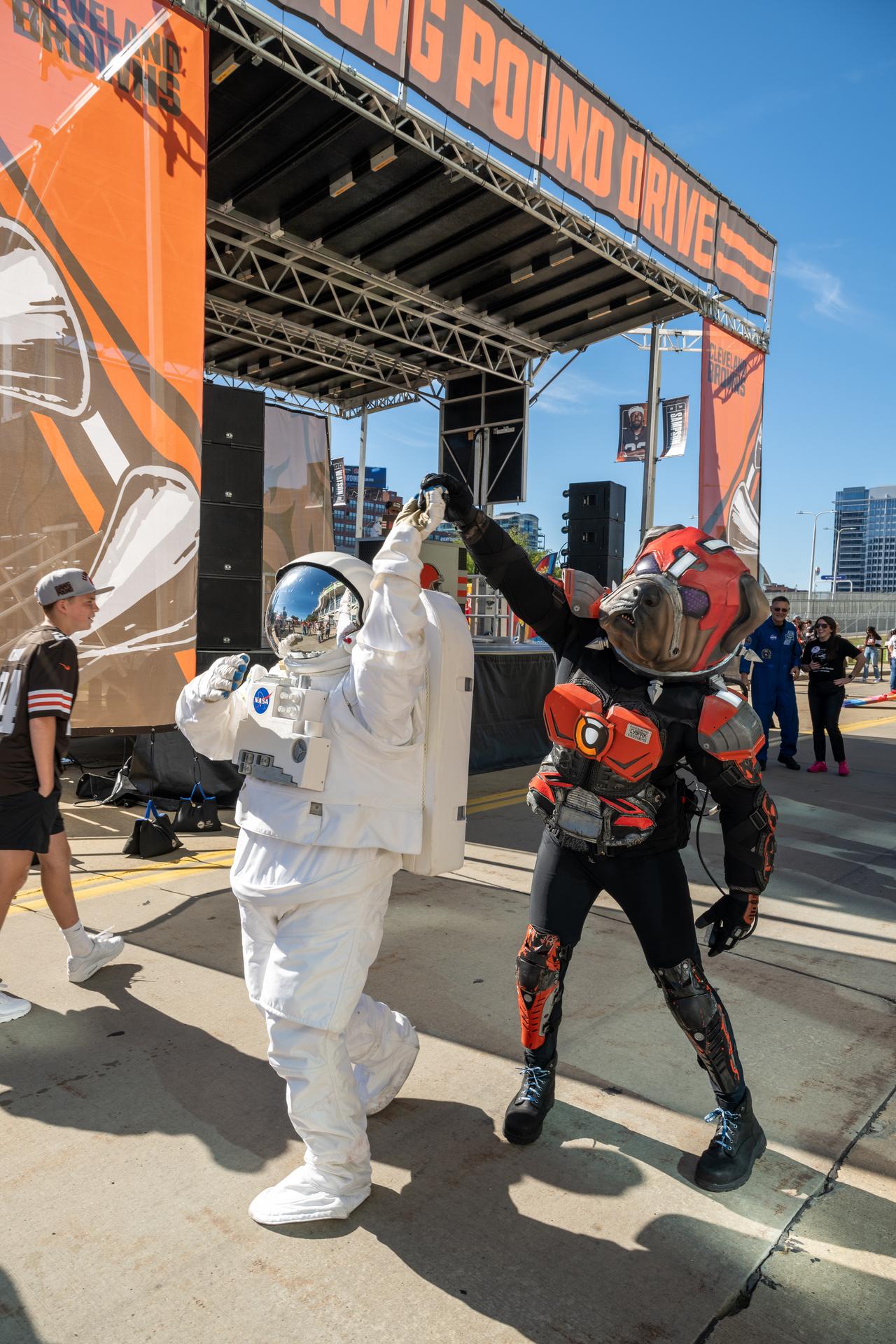 Eva the Astronaut poses with a Brown's fan at an NFL game between the Cleveland Browns and the Carolina Panthers at Huntington Bank Field, Sunday, September 27th, 2026, in Cleveland, Ohio. NASA’s engagement at NFL games is part of the agency’s Inspiration Tour, aimed at strengthening connections between NASA and its partners and showcasing innovation in air and space in the lead up to the MAX POWER aerospace technology expo and airshow at the agency’s Kennedy Space Center in early November. Photo Credit: (NASA/Jordan Cochran)