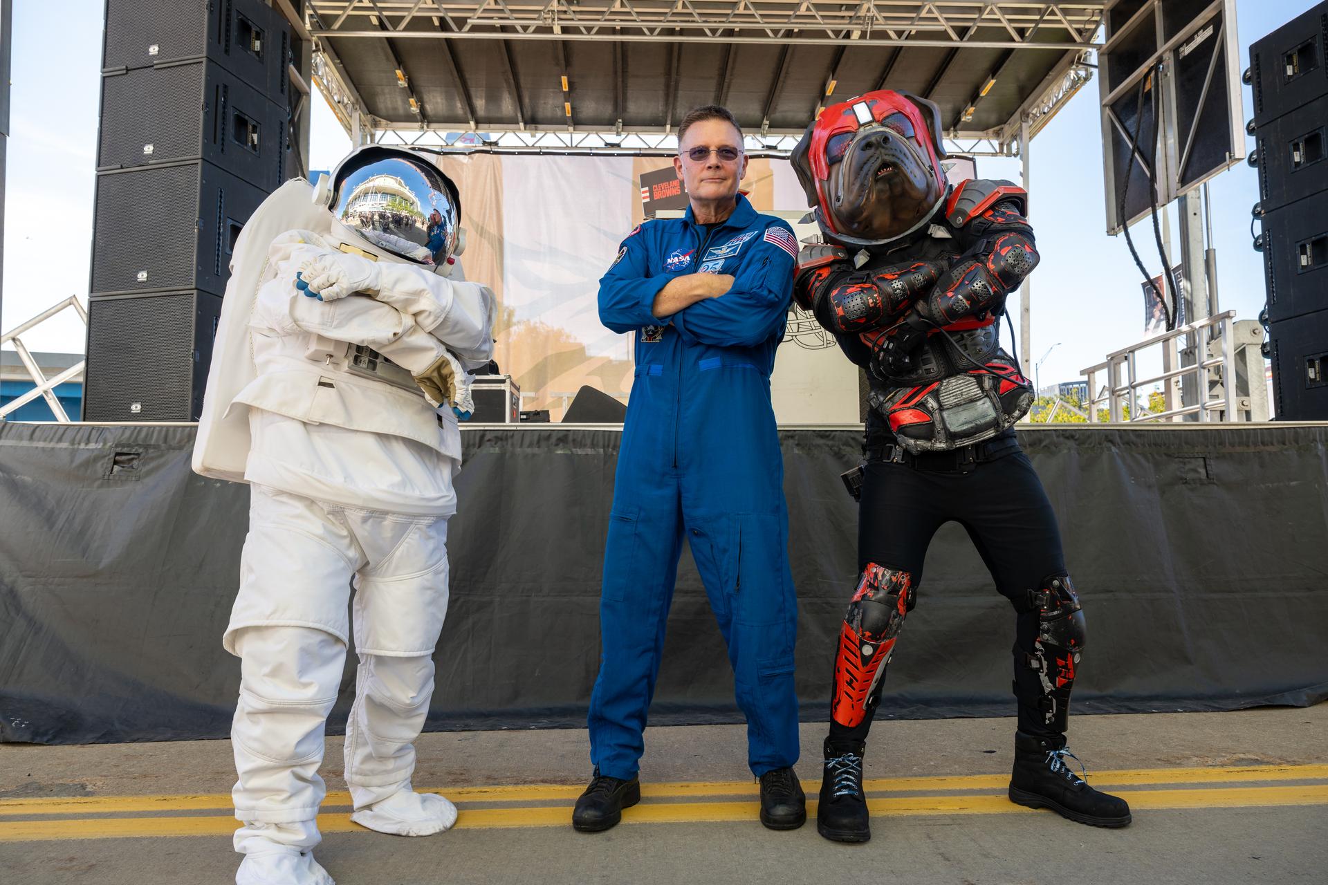 Eva the Astronaut and NASA Astronaut Douglas Wheelock pose with a Brown's fan at an NFL game between the Cleveland Browns and the Carolina Panthers at Huntington Bank Field, Sunday, September 27th, 2026, in Cleveland, Ohio. NASA’s engagement at NFL games is part of the agency’s Inspiration Tour, aimed at strengthening connections between NASA and its partners and showcasing innovation in air and space in the lead up to the MAX POWER aerospace technology expo and airshow at the agency’s Kennedy Space Center in early November. Photo Credit: (NASA/Jordan Cochran)