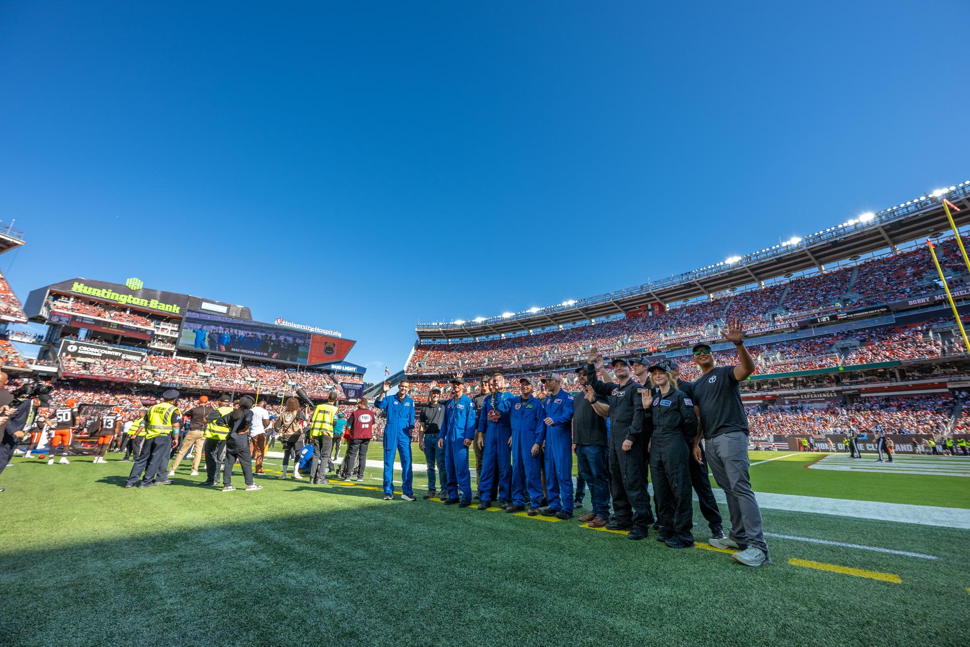 NASA Administrator Jared Isaacman and his Freedom 250 F-5 team (Jerry "Jive" Kerby, Doug "Tut" Demko and other members) along with NASA Astronaut Douglas Wheelock and Associate Administrator, Research and Technology Mission Directorate Dr. James Kenyon wave to fans on the field at an NFL game between the Cleveland Browns and the Carolina Panthers at Huntington Bank Field, Sunday, September 27th, 2026, in Cleveland, Ohio. NASA’s engagement at NFL games is part of the agency’s Inspiration Tour, aimed at strengthening connections between NASA and its partners and showcasing innovation in air and space in the lead up to the MAX POWER aerospace technology expo and airshow at the agency’s Kennedy Space Center in early November. Photo Credit: (NASA/Jordan Cochran)