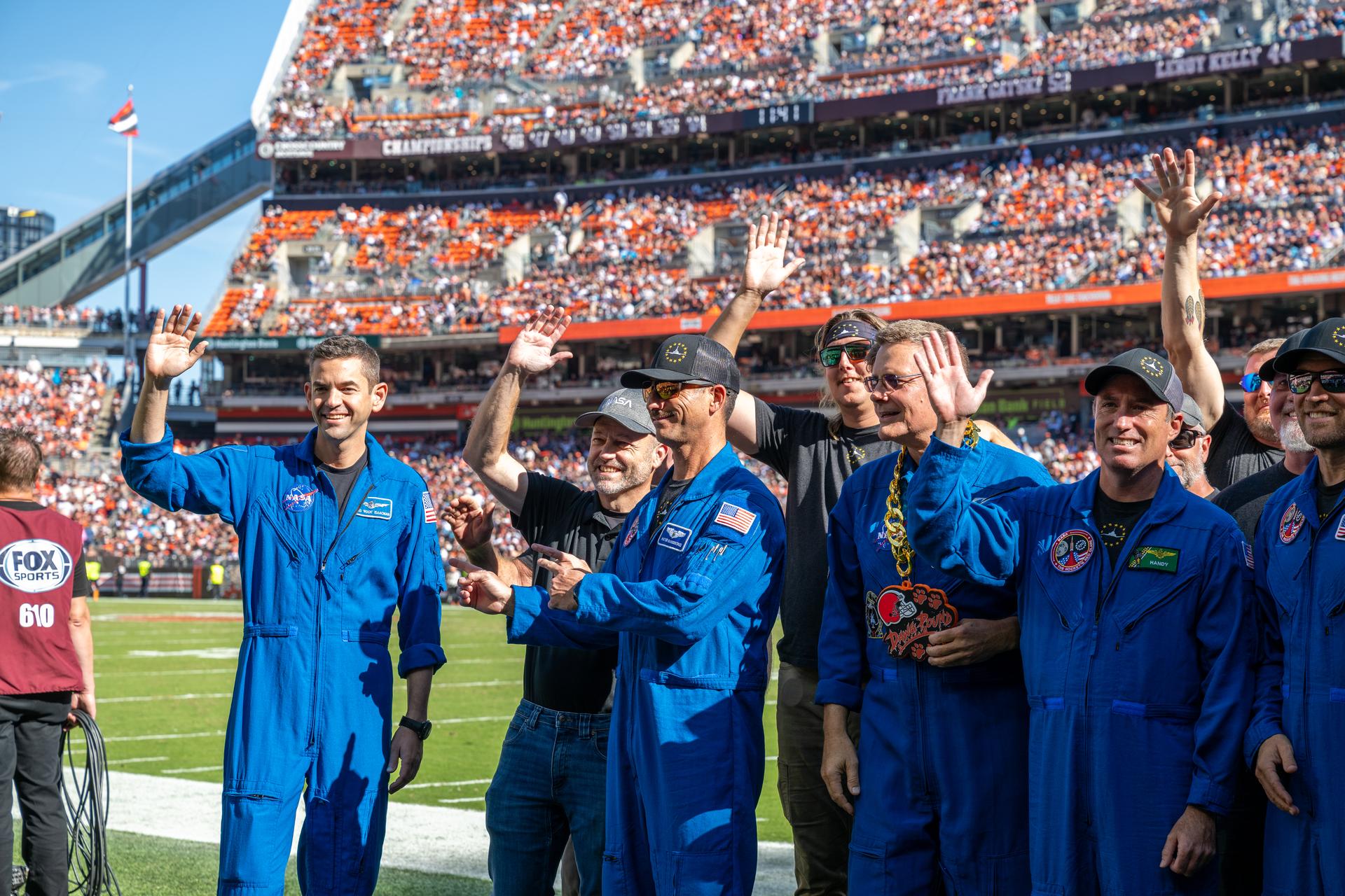 NASA Administrator Jared Isaacman and his Freedom 250 F-5 team (Jerry "Jive" Kerby, Doug "Tut" Demko and other members) along with NASA Astronaut Douglas Wheelock and Associate Administrator, Research and Technology Mission Directorate Dr. James Kenyon wave to fans on the field at an NFL game between the Cleveland Browns and the Carolina Panthers at Huntington Bank Field, Sunday, September 27th, 2026, in Cleveland, Ohio. NASA’s engagement at NFL games is part of the agency’s Inspiration Tour, aimed at strengthening connections between NASA and its partners and showcasing innovation in air and space in the lead up to the MAX POWER aerospace technology expo and airshow at the agency’s Kennedy Space Center in early November. Photo Credit: (NASA/Jordan Cochran)