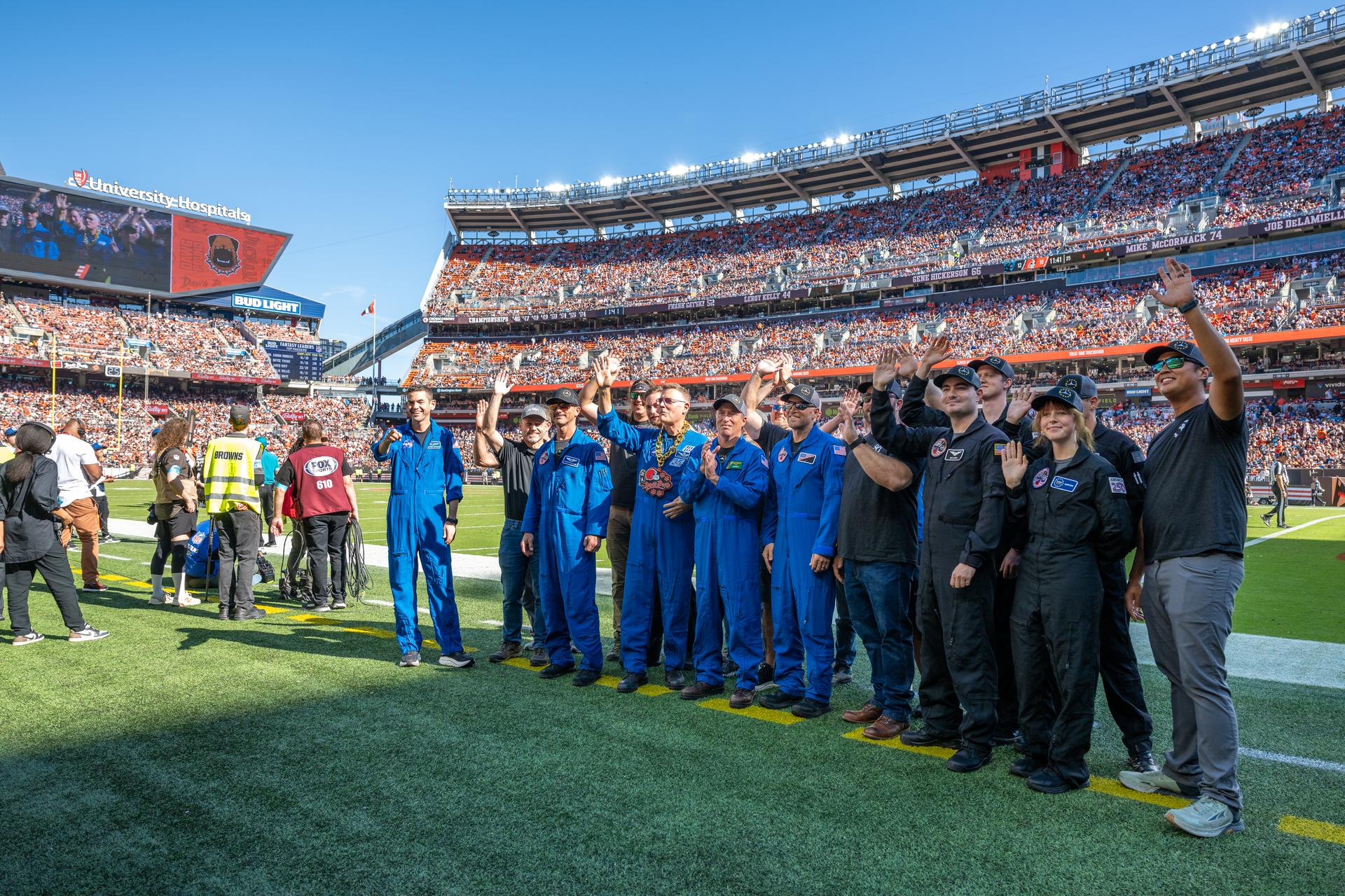 NASA Administrator Jared Isaacman and his Freedom 250 F-5 team (Jerry "Jive" Kerby, Doug "Tut" Demko and other members) along with NASA Astronaut Douglas Wheelock and Associate Administrator, Research and Technology Mission Directorate Dr. James Kenyon wave to fans on the field at an NFL game between the Cleveland Browns and the Carolina Panthers at Huntington Bank Field, Sunday, September 27th, 2026, in Cleveland, Ohio. NASA’s engagement at NFL games is part of the agency’s Inspiration Tour, aimed at strengthening connections between NASA and its partners and showcasing innovation in air and space in the lead up to the MAX POWER aerospace technology expo and airshow at the agency’s Kennedy Space Center in early November. Photo Credit: (NASA/Jordan Cochran)