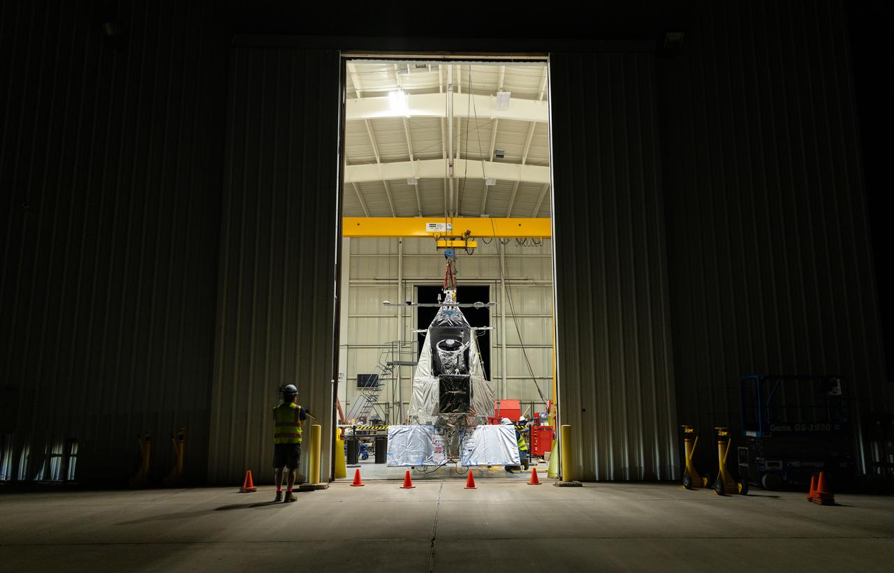NASA Goddard astrophysicist Kyle Helson looks at EXCITE (EXoplanet Climate Infrared TElescope) as it dangles from the ceiling of a hangar at NASA’s Columbia Scientific Balloon Facility in Fort Sumner, New Mexico.