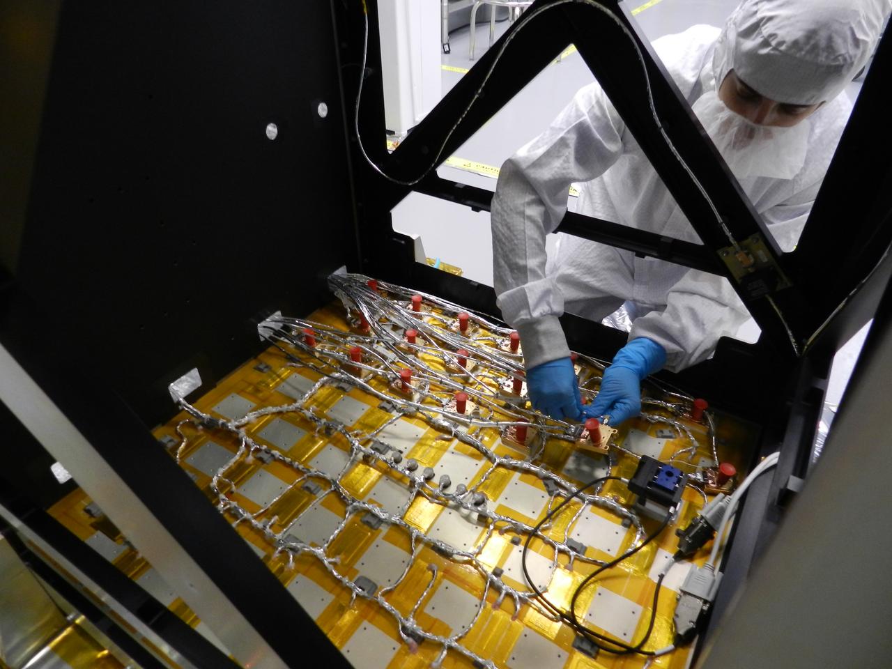 NICER engineer Steven Kenyon installs an X-ray detector onto the payload’s detector plate. The detectors are protected by red caps during installation because they are very sensitive to dust and other foreign object debris. The Neutron star Interior Composition Explorer (NICER) is a NASA Explorer Mission of Opportunity dedicated to studying the extraordinary environments — strong gravity, ultra-dense matter, and the most powerful magnetic fields in the universe — embodied by neutron stars. An attached payload aboard the International Space Station, NICER will deploy an instrument with unique capabilities for timing and spectroscopy of fast X-ray brightness fluctuations. The embedded Station Explorer for X-ray Timing and Navigation Technology demonstration (SEXTANT) will use NICER data to validate, for the first time in space, technology that exploits pulsars as natural navigation beacons. Credit: NASA/Goddard/ Keith Gendreau <b><a href="http://www.nasa.gov/audience/formedia/features/MP_Photo_Guidelines.html" rel="nofollow">NASA image use policy.</a></b> <b><a href="http://www.nasa.gov/centers/goddard/home/index.html" rel="nofollow">NASA Goddard Space Flight Center</a></b> enables NASA’s mission through four scientific endeavors: Earth Science, Heliophysics, Solar System Exploration, and Astrophysics. Goddard plays a leading role in NASA’s accomplishments by contributing compelling scientific knowledge to advance the Agency’s mission. <b>Follow us on <a href="http://twitter.com/NASAGoddardPix" rel="nofollow">Twitter</a></b> <b>Like us on <a href="http://www.facebook.com/pages/Greenbelt-MD/NASA-Goddard/395013845897?ref=tsd" rel="nofollow">Facebook</a></b> <b>Find us on <a href="http://instagrid.me/nasagoddard/?vm=grid" rel="nofollow">Instagram</a></b>
