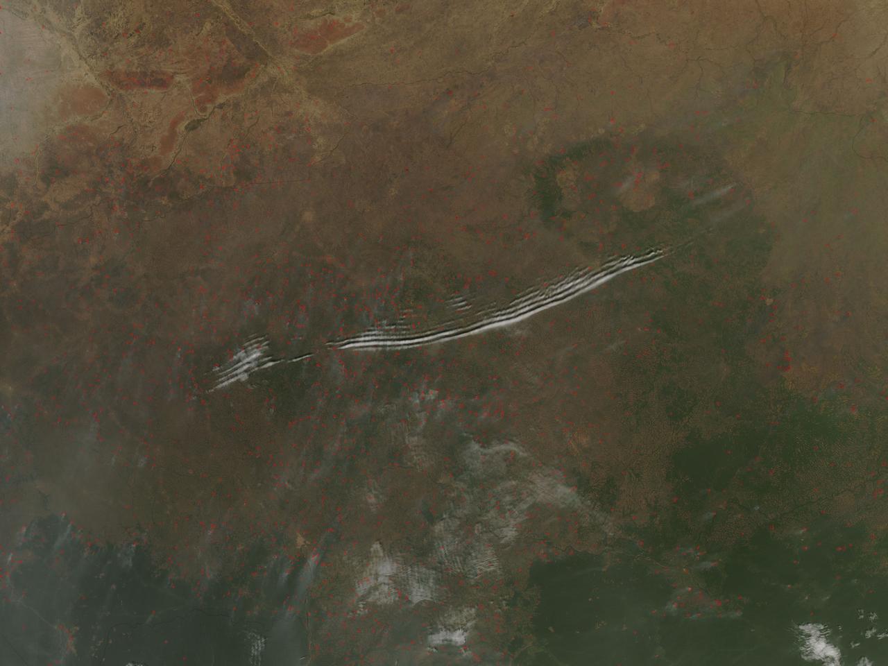    On January 27, 2016, the Moderate Resolution Imaging Spectroradiometer (MODIS) aboard NASA’s Aqua satellite passed over the Central African Republic and captured a true-color image of wave clouds rippling over a fire-speckled landscape.  Wave clouds typically form when a mountain, island, or even another mass of air forces an air mass to rise, then fall again, in a wave pattern. The air cools as it rises, and if there is moisture in the air, the water condenses into clouds at the top of the wave. As the air begins to sink, the air warms and the cloud dissipates. The result is a line of clouds marking the crests of the wave separated by clear areas in the troughs of the wave.  In addition to the long lines of clouds stretching across the central section of the country, clouds appear to line up in parallel rows near the border of the Democratic Republic of the Congo. In this area, small sets of grayish cloud appear to be lined up with the prevailing wind, judging by the plumes of smoke rising from red hotspots near each set of clouds. Clouds like this, that line in parallel rows parallel with the prevailing wind, are known as “cloud streets”.  Each red “hotspot” marks an area where the thermal sensors on the MODIS instrument detected high temperatures. When accompanied by typical smoke, such hotspots are diagnostic for actively burning fires. Given the time of the year, the widespread nature, and the location of the fires, they are almost certainly agricultural fires that have been deliberately set to manage land.  Image Credit: Jeff Schmaltz, MODIS Land Rapid Response Team, NASA GSFC  <b><a href="http://www.nasa.gov/audience/formedia/features/MP_Photo_Guidelines.html" rel="nofollow">NASA image use policy.</a></b>  <b><a href="http://www.nasa.gov/centers/goddard/home/index.html" rel="nofollow">NASA Goddard Space Flight Center</a></b> enables NASA’s mission through four scientific endeavors: Earth Science, Heliophysics, Solar System Exploration, and Astrophysics. Goddard plays a leading role in NASA’s accomplishments by contributing compelling scientific knowledge to advance the Agency’s mission.  <b>Follow us on <a href="http://twitter.com/NASAGoddardPix" rel="nofollow">Twitter</a></b>  <b>Like us on <a href="http://www.facebook.com/pages/Greenbelt-MD/NASA-Goddard/395013845897?ref=tsd" rel="nofollow">Facebook</a></b>  <b>Find us on <a href="http://instagrid.me/nasagoddard/?vm=grid" rel="nofollow">Instagram</a></b>  