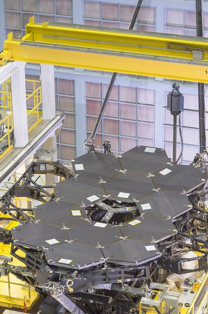 A view of the one dozen (out of 18) flight mirror segments that make up the primary mirror on NASA's James Webb Space Telescope have been installed at NASA's Goddard Space Flight Center.  Credits: NASA/Chris Gunn  More: Since December 2015, the team of scientists and engineers have been working tirelessly to install all the primary mirror segments onto the telescope structure in the large clean room at NASA's Goddard Space Flight Center in Greenbelt, Maryland. The twelfth mirror was installed on January 2, 2016.  &quot;This milestone signifies that all of the hexagonal shaped mirrors on the fixed central section of the telescope structure are installed and only the 3 mirrors on each wing are left for installation,&quot; said Lee Feinberg, NASA's Optical Telescope Element Manager at NASA Goddard. &quot;The incredibly skilled and dedicated team assembling the telescope continues to find ways to do things faster and more efficiently.&quot;  Each hexagonal-shaped segment measures just over 4.2 feet (1.3 meters) across and weighs approximately 88 pounds (40 kilograms). After being pieced together, the 18 primary mirror segments will work together as one large 21.3-foot (6.5-meter) mirror. The primary mirror will unfold and adjust to shape after launch. The mirrors are made of ultra-lightweight beryllium. The mirrors are placed on the telescope's backplane using a robotic arm, guided by engineers. The full installation is expected to be completed in a few months.  The mirrors were built by Ball Aerospace &amp; Technologies Corp., Boulder, Colorado. Ball is the principal subcontractor to Northrop Grumman for the optical technology and lightweight mirror system. The installation of the mirrors onto the telescope structure is performed by Harris Corporation of Rochester, New York. Harris Corporation leads integration and testing for the telescope.  While the mirror assembly is a very significant milestone, there are many more steps involved in assembling the Webb telescope. The primary mirror and the tennis-court-sized sunshield are the largest and most visible components of the Webb telescope. However, there are four smaller components that are less visible, yet critical.  The instruments that will fly aboard Webb - cameras and spectrographs with detectors able to record extremely faint signals — are part of the Integrated Science Instrument Module (ISIM), which is currently undergoing its final cryogenic vacuum test and will be integrated with the mirror later this year. Read more: <a href="http://www.nasa.gov/feature/goddard/2016/by-the-dozen-nasas-james-webb-space-telescope-mirrors" rel="nofollow">www.nasa.gov/feature/goddard/2016/by-the-dozen-nasas-jame...</a>  <b><a href="http://www.nasa.gov/audience/formedia/features/MP_Photo_Guidelines.html" rel="nofollow">NASA image use policy.</a></b>  <b><a href="http://www.nasa.gov/centers/goddard/home/index.html" rel="nofollow">NASA Goddard Space Flight Center</a></b> enables NASA’s mission through four scientific endeavors: Earth Science, Heliophysics, Solar System Exploration, and Astrophysics. Goddard plays a leading role in NASA’s accomplishments by contributing compelling scientific knowledge to advance the Agency’s mission.  <b>Follow us on <a href="http://twitter.com/NASAGoddardPix" rel="nofollow">Twitter</a></b>  <b>Like us on <a href="http://www.facebook.com/pages/Greenbelt-MD/NASA-Goddard/395013845897?ref=tsd" rel="nofollow">Facebook</a></b>  <b>Find us on <a href="http://instagrid.me/nasagoddard/?vm=grid" rel="nofollow">Instagram</a></b>   