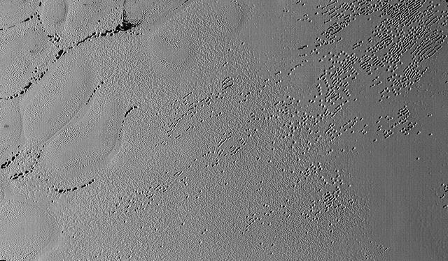 This image was taken by the Long Range Reconnaissance Imager (LORRI) on NASA's New Horizons spacecraft shortly before closest approach to Pluto on July 14, 2015; it resolves details as small as 270 yards (250 meters). The scene shown is about 130 miles (210 kilometers) across. The sun illuminates the scene from the left, and north is to the upper left. Credits: NASA/JHUAPL/SwRI It seems that the more we see of Pluto, the more fascinating it gets. With its prominent heart-shaped feature, icy mountains, and “snakeskin” terrain, Pluto has already surprised New Horizons scientists with the variety and complexity of its surface features. Now this latest image, from the heart of Pluto’s heart feature, show the plains’ enigmatic cellular pattern (at left) as well as unusual clusters of small pits and troughs (from lower left to upper right). Scientists believe that this area, informally known as Sputnik Planum, is composed of volatile ices such as solid nitrogen. They theorize that the pits and troughs – typically hundreds of meters across and tens of meters deep – are possibly formed by sublimation or evaporation of these ices. However, the reasons for the striking shapes and alignments of these features are a mystery. Adding to the intrigue is that even at this resolution, no impact craters are seen, testifying to the extreme geologic youth of Sputnik Planum. “Pluto is weird, in a good way,” said Hal Weaver, New Horizons project scientist with Johns Hopkins Applied Physics Laboratory in Laurel, Maryland. “The pits, and the way they’re aligned, provide clues about the ice flow and the exchange of volatiles between the surface and atmosphere, and the science team is working hard to understand what physical processes are at play here.” <b><a href="http://www.nasa.gov/audience/formedia/features/MP_Photo_Guidelines.html" rel="nofollow">NASA image use policy.</a></b> <b><a href="http://www.nasa.gov/centers/goddard/home/index.html" rel="nofollow">NASA Goddard Space Flight Center</a></b> enables NASA’s mission through four scientific endeavors: Earth Science, Heliophysics, Solar System Exploration, and Astrophysics. Goddard plays a leading role in NASA’s accomplishments by contributing compelling scientific knowledge to advance the Agency’s mission. <b>Follow us on <a href="http://twitter.com/NASAGoddardPix" rel="nofollow">Twitter</a></b> <b>Like us on <a href="http://www.facebook.com/pages/Greenbelt-MD/NASA-Goddard/395013845897?ref=tsd" rel="nofollow">Facebook</a></b> <b>Find us on <a href="http://instagrid.me/nasagoddard/?vm=grid" rel="nofollow">Instagram</a></b>
