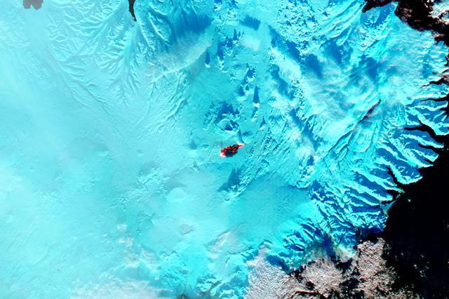 The main caldera of Bardarbunga volcano is tucked beneath Iceland’s largest glacier, Vatnajökull. Beginning in August, 2014, red-hot basaltic lava originating from Bardarbunga has been pouring from fissures just north of Vatnajökull, creating the massive Holuhraun lava field. As of January 6, 2015, the Holuhraun lava field had spread across more than 84 square kilometers (32 square miles), making it larger than the island of Manhattan. Holuhraun is Iceland’s largest basaltic lava flow since the Laki eruption in 1783–84, an event that killed 20 percent of the island’s population.  Scientists from the University of Iceland’s Institute of Earth Sciences have estimated the thickness of the lava field based on data from surveillance flights. On average, the eastern part was about 10 meters (33 feet) thick, the center was 12 meters, and the western part was 14 meters. Their preliminary analysis put the volume of lava at 1.1 cubic kilometers, enough for the eruption to be considered a flood basalt.  While Holuhraun continues to spew copious amounts of lava and sulfur dioxide, some observations suggest the eruption may be slowing down. As Edinburgh University volcanologist John Stevenson noted on his blog, Icelandic scientists have shown that the sinking (subsidence) of the caldera has declined from 80 centimeters (31 inches) to 25 centimeters per day—a sign that less magma is moving toward the surface. In addition, magnitude 5 or higher earthquakes that used to occur daily are now happening about once a week. Meanwhile, satellite observations of heat flux show a decline from more than 20 gigawatts in early September to fewer than 5 gigawatts by the end of November. As reported by Volcano Discovery, one bold scientist has even suggested that it is reasonable to forecast that the eruption may be over by March, 2015.  The Moderate Resolution Imaging Spectrometer (MODIS) aboard NASA’s Aqua satellite flew over Iceland on January 18, 2015 and captured a false-color image of the lava field. In this image, clouds are bright white, cold snow is electric blue, and the North Atlantic Ocean is inky blue-black. Fresh lava appears bright red, while newly formed basaltic rock in the lava field, cooler than the fresh lava, appears black.  Credit: NASA/GSFC/Jeff Schmaltz/MODIS Land Rapid Response Team    <b><a href="http://www.nasa.gov/audience/formedia/features/MP_Photo_Guidelines.html" rel="nofollow">NASA image use policy.</a></b>  <b><a href="http://www.nasa.gov/centers/goddard/home/index.html" rel="nofollow">NASA Goddard Space Flight Center</a></b> enables NASA’s mission through four scientific endeavors: Earth Science, Heliophysics, Solar System Exploration, and Astrophysics. Goddard plays a leading role in NASA’s accomplishments by contributing compelling scientific knowledge to advance the Agency’s mission. <b>Follow us on <a href="http://twitter.com/NASAGoddardPix" rel="nofollow">Twitter</a></b> <b>Like us on <a href="http://www.facebook.com/pages/Greenbelt-MD/NASA-Goddard/395013845897?ref=tsd" rel="nofollow">Facebook</a></b> <b>Find us on <a href="http://instagram.com/nasagoddard?vm=grid" rel="nofollow">Instagram</a></b> 