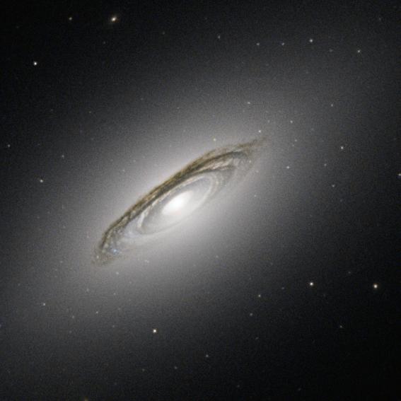The subject of this image is NGC 6861, a galaxy discovered in 1826 by the Scottish astronomer James Dunlop. Almost two centuries later we now know that NGC 6861 is the second brightest member of a group of at least a dozen galaxies called the Telescopium Group — otherwise known as the NGC 6868 Group — in the small constellation of Telescopium (The Telescope).  This NASA/ESA Hubble Space Telescope view shows some important details of NGC 6861. One of the most prominent features is the disk of dark bands circling the centre of the galaxy. These dust lanes are a result of large clouds of dust particles obscuring the light emitted by the stars behind them.  Dust lanes are very useful for working out whether we are seeing the galaxy disk edge-on, face-on or, as is the case for NGC 6861, somewhat in the middle. Dust lanes like these are typical of a spiral galaxy. The dust lanes are embedded in a white oval shape, which is made up of huge numbers of stars orbiting the center of the galaxy. This oval is, rather puzzlingly, typical of an elliptical galaxy.  So which is it — spiral or elliptical? The answer is neither! NGC 6861 does not belong to either the spiral or the elliptical family of galaxies. It is a lenticular galaxy, a family which has features of both spirals and ellipticals.  The relationships between these three kinds of galaxies are not yet well understood. A lenticular galaxy could be a faded spiral that has run out of gas and lost its arms, or the result of two galaxies merging. Being part of a group increases the chances for galactic mergers, so this could be the case for NGC 6861.  Credit: ESA/Hubble &amp; NASA; acknowledgement: J. Barrington  <b><a href="http://www.nasa.gov/audience/formedia/features/MP_Photo_Guidelines.html" rel="nofollow">NASA image use policy.</a></b>  <b><a href="http://www.nasa.gov/centers/goddard/home/index.html" rel="nofollow">NASA Goddard Space Flight Center</a></b> enables NASA’s mission through four scientific endeavors: Earth Science, Heliophysics, Solar System Exploration, and Astrophysics. Goddard plays a leading role in NASA’s accomplishments by contributing compelling scientific knowledge to advance the Agency’s mission. <b>Follow us on <a href="http://twitter.com/NASAGoddardPix" rel="nofollow">Twitter</a></b> <b>Like us on <a href="http://www.facebook.com/pages/Greenbelt-MD/NASA-Goddard/395013845897?ref=tsd" rel="nofollow">Facebook</a></b> <b>Find us on <a href="http://instagram.com/nasagoddard?vm=grid" rel="nofollow">Instagram</a></b>