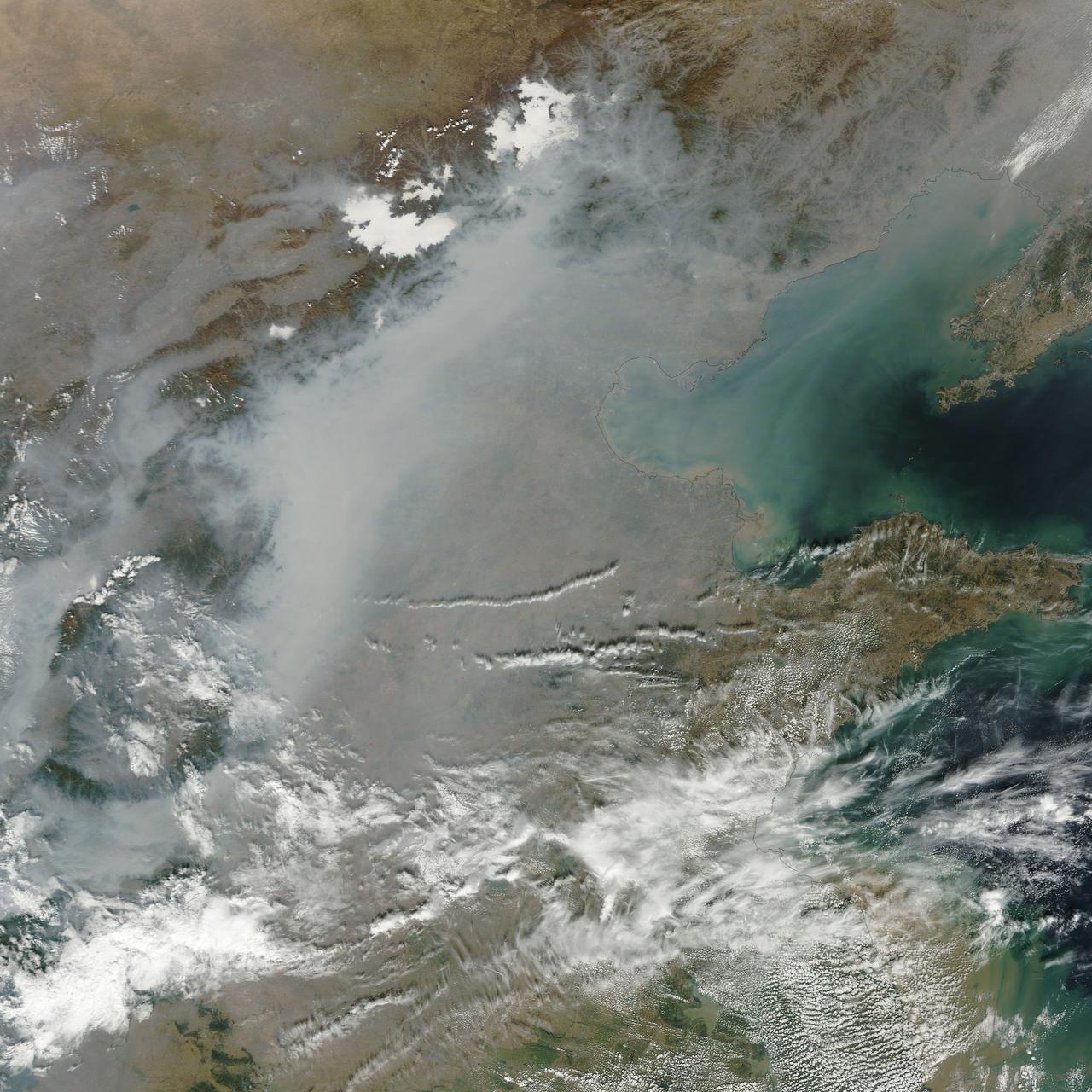 A thick layer of haze blanketed the North China Plain on October 9, 2014, when the Moderate Resolution Imaging Spectroradiometer (MODIS) on NASA’s Terra satellite acquired this natural-color image at 2:50 Coordinated Universal Time (10:50 a.m. local time). The haze obscured many features usually visible in MODIS imagery of the area, including China’s largest city, Beijing.  On the day this image was acquired, measurements from ground-based sensors at the U.S. Consulate in Beijing reported PM2.5 measurements of 334 micrograms per cubic meter of air. Fine, airborne particulate matter (PM) that is smaller than 2.5 microns (about one thirtieth the width of a human hair) is considered dangerous because it is small enough to enter the passages of the human lungs. Most PM2.5 aerosol particles come from the burning of fossil fuels and biomass (wood fires and agricultural burning). The World Health Organization considers PM2.5 to be safe when it is below 25.  Haze in this region tends to worsen in the fall and winter, when cold, heavy air traps pollutants near the surface. In this case, the haze was likely trapped by a temperature inversion. Normally, air is warmest near the surface of the Earth. Occasionally, a mass of warm air will move over cooler air so that the atmosphere actually warms with altitude. Since the cool air does not have the energy to rise through the warm air, vertical circulation slows and air becomes trapped near the surface. Any pollutant that enters the air gets trapped as well, and haze builds up over time.  Daily satellite images of the North China Plain show that visible haze began to accumulate on October 7, 2014.  NASA image courtesy Jeff Schmaltz, LANCE MODIS Rapid Response. Caption by Adam Voiland.  Read more: <a href="http://earthobservatory.nasa.gov/NaturalHazards/view.php?id=84530&amp;eocn=home&amp;eoci=nh" rel="nofollow">earthobservatory.nasa.gov/NaturalHazards/view.php?id=8453...</a>  Credit: <b><a href="http://www.earthobservatory.nasa.gov/" rel="nofollow"> NASA Earth Observatory</a></b>  <b><a href="http://www.nasa.gov/audience/formedia/features/MP_Photo_Guidelines.html" rel="nofollow">NASA image use policy.</a></b>  <b><a href="http://www.nasa.gov/centers/goddard/home/index.html" rel="nofollow">NASA Goddard Space Flight Center</a></b> enables NASA’s mission through four scientific endeavors: Earth Science, Heliophysics, Solar System Exploration, and Astrophysics. Goddard plays a leading role in NASA’s accomplishments by contributing compelling scientific knowledge to advance the Agency’s mission. <b>Follow us on <a href="http://twitter.com/NASAGoddardPix" rel="nofollow">Twitter</a></b> <b>Like us on <a href="http://www.facebook.com/pages/Greenbelt-MD/NASA-Goddard/395013845897?ref=tsd" rel="nofollow">Facebook</a></b> <b>Find us on <a href="http://instagram.com/nasagoddard?vm=grid" rel="nofollow">Instagram</a></b>