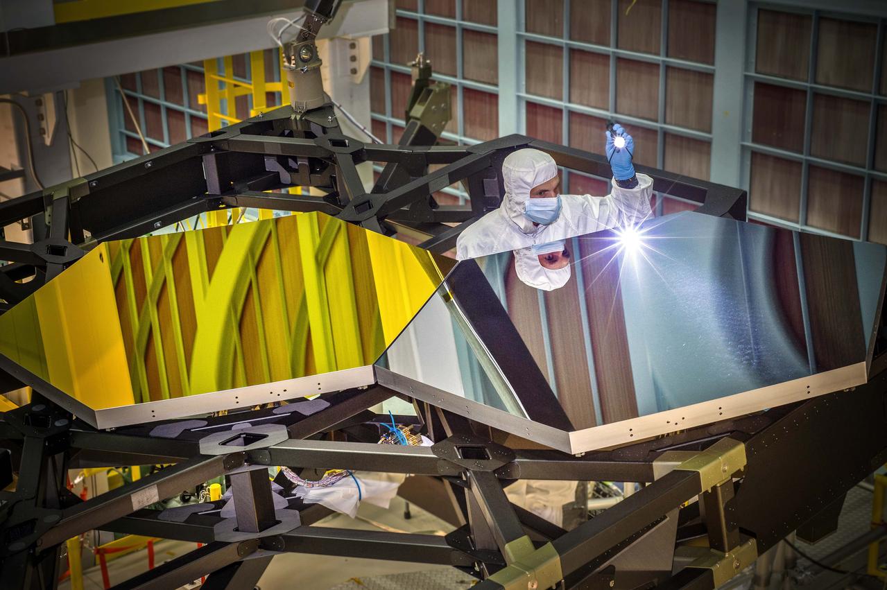 Inside NASA's Goddard Space Flight Center's giant clean room in Greenbelt, Md., JWST Optical Engineer Larkin Carey from Ball Aerospace, examines two test mirror segments recently placed on a black composite structure. This black composite structure is called the James Webb Space Telescope's “Pathfinder” and acts as a spine supporting the telescope's primary mirror segments. The Pathfinder is a non-flight prototype.   The mirrors were placed on Pathfinder using a robotic arm move that involved highly trained engineers and technicians from Exelis, Northrop Grumman and NASA.   &quot;Getting this right is critical to proving we are ready to start assembling the flight mirrors onto the flight structure next summer,&quot; said Lee Feinberg, NASA's Optical Telescope Element Manager at NASA Goddard. &quot;This is the first space telescope that has ever been built with a light-weighted segmented primary mirror, so learning how to do this is a groundbreaking capability for not only the Webb telescope but for potential future space telescopes.&quot;   The James Webb Space Telescope is the successor to NASA's Hubble Space Telescope. It will be the most powerful space telescope ever built. Webb is an international project led by NASA with its partners, the European Space Agency and the Canadian Space Agency.   For more information about the Webb telescope, visit: <a href="http://www.jwst.nasa.gov" rel="nofollow">www.jwst.nasa.gov</a> or <a href="http://www.nasa.gov/webb" rel="nofollow">www.nasa.gov/webb</a>   Credit: NASA/Chris Gunn  <b><a href="http://www.nasa.gov/audience/formedia/features/MP_Photo_Guidelines.html" rel="nofollow">NASA image use policy.</a></b>  <b><a href="http://www.nasa.gov/centers/goddard/home/index.html" rel="nofollow">NASA Goddard Space Flight Center</a></b> enables NASA’s mission through four scientific endeavors: Earth Science, Heliophysics, Solar System Exploration, and Astrophysics. Goddard plays a leading role in NASA’s accomplishments by contributing compelling scientific knowledge to advance the Agency’s mission. <b>Follow us on <a href="http://twitter.com/NASAGoddardPix" rel="nofollow">Twitter</a></b> <b>Like us on <a href="http://www.facebook.com/pages/Greenbelt-MD/NASA-Goddard/395013845897?ref=tsd" rel="nofollow">Facebook</a></b> <b>Find us on <a href="http://instagram.com/nasagoddard?vm=grid" rel="nofollow">Instagram</a></b>