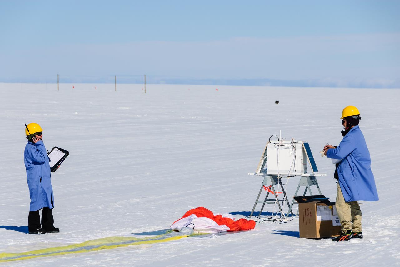 Researchers communicate with the BARREL ground station during preparations for launch. The white box in the background is the science payload and the orange and white parachute can be seen on the ground in front of it.  On the left is BARREL Principal Investigator Robyn Millan of Dartmouth College in Hanover, N.H.; on the right is BARREL Co-Investigator Michael McCarthy of the University of Washington in Seattle.   Credit: NASA/Goddard/BARREL/M. Krzysztofowicz  Read more: <a href="http://www.nasa.gov/content/goddard/nasas-barrel-returns-successful-from-antarctica" rel="nofollow">www.nasa.gov/content/goddard/nasas-barrel-returns-success...</a>  --  Three months, 20 balloons, and one very successful campaign.  The team for NASA's BARREL – short for Balloon Array for Radiation belt Relativistic Electron Losses -- mission returned from Antarctica in March 2014.  BARREL's job is to help unravel the mysterious Van Allen belts, two gigantic donuts of radiation that surround Earth, which can shrink and swell in response to incoming energy and particles from the sun and sometimes expose satellites to harsh radiation.   While in Antarctica, the team launched 20 balloons carrying instruments that sense charged particles that are scattered into the atmosphere from the belts, spiraling down the magnetic fields near the South Pole. Each balloon traveled around the pole for up to three weeks. The team will coordinate the BARREL data with observations from NASA's two Van Allen Probes to better understand how occurrences in the belts relate to bursts of particles funneling down toward Earth.   BARREL team members will be on hand at the USA Science and Engineering Festival in DC on April 26 and 27, 2014 for the exhibit Space Balloons: Exploring the Extremes of Space Weather.   <b><a href="http://www.nasa.gov/audience/formedia/features/MP_Photo_Guidelines.html" rel="nofollow">NASA image use policy.</a></b>  <b><a href="http://www.nasa.gov/centers/goddard/home/index.html" rel="nofollow">NASA Goddard Space Flight Center</a></b> enables NASA’s mission through four scientific endeavors: Earth Science, Heliophysics, Solar System Exploration, and Astrophysics. Goddard plays a leading role in NASA’s accomplishments by contributing compelling scientific knowledge to advance the Agency’s mission.  <b>Follow us on <a href="http://twitter.com/NASAGoddardPix" rel="nofollow">Twitter</a></b>  <b>Like us on <a href="http://www.facebook.com/pages/Greenbelt-MD/NASA-Goddard/395013845897?ref=tsd" rel="nofollow">Facebook</a></b>  <b>Find us on <a href="http://instagram.com/nasagoddard?vm=grid" rel="nofollow">Instagram</a></b>