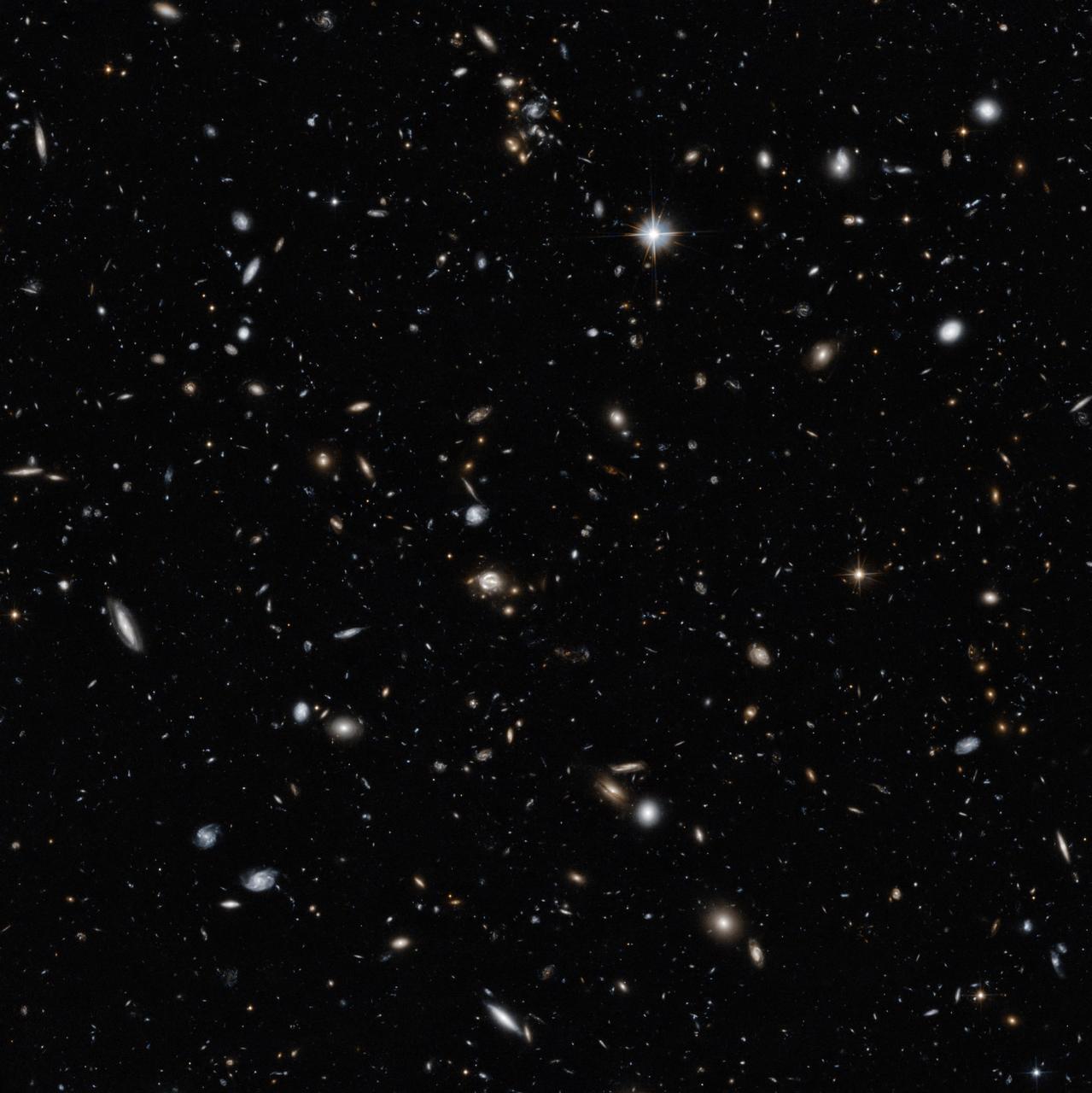 This new Hubble image showcases a remarkable variety of objects at different distances from us, extending back over halfway to the edge of the observable Universe. The galaxies in this image mostly lie about five billion light-years from Earth but the field also contains other objects, both significantly closer and far more distant.  Studies of this region of the sky have shown that many of the objects that appear to lie close together may actually be billions of light-years apart. This is because several groups of galaxies lie along our line of sight, creating something of an optical illusion. Hubble’s cross-section of the Universe is completed by distorted images of galaxies in the very distant background.  These objects are sometimes distorted due to a process called gravitational lensing, an extremely valuable technique in astronomy for studying very distant objects [1]. This lensing is caused by the bending of the space-time continuum by massive galaxies lying close to our line of sight to distant objects.  One of the lens systems visible here is called CLASS B1608+656, which appears as a small loop in the centre of the image. It features two foreground galaxies distorting and amplifying the light of a distant quasar the known as QSO-160913+653228. The light from this bright disc of matter, which is currently falling into a black hole, has taken nine billion years to reach us — two thirds of the age of the Universe.  As well as CLASS B1608+656, astronomers have identified two other gravitational lenses within this image. Two galaxies, dubbed Fred and Ginger by the researchers who studied them, contain enough mass to visibly distort the light from objects behind them. Fred, also known more prosaically as [FMK2006] ACS J160919+6532, lies near the lens galaxies in CLASS B1608+656, while Ginger ([FMK2006] ACS J160910+6532) is markedly closer to us. Despite their different distances from us, both can be seen near to CLASS B1608+656 in the central region of this Hubble image.  To capture distant and dim objects like these, Hubble required a long exposure. The image is made up of visible and infrared observations with a total exposure time of 14 hours.  More info: <a href="http://www.spacetelescope.org/news/heic1408/" rel="nofollow">www.spacetelescope.org/news/heic1408/</a>  Credit: NASA/ESA/Hubble  <b><a href="http://www.nasa.gov/audience/formedia/features/MP_Photo_Guidelines.html" rel="nofollow">NASA image use policy.</a></b>  <b><a href="http://www.nasa.gov/centers/goddard/home/index.html" rel="nofollow">NASA Goddard Space Flight Center</a></b> enables NASA’s mission through four scientific endeavors: Earth Science, Heliophysics, Solar System Exploration, and Astrophysics. Goddard plays a leading role in NASA’s accomplishments by contributing compelling scientific knowledge to advance the Agency’s mission.  <b>Follow us on <a href="http://twitter.com/NASAGoddardPix" rel="nofollow">Twitter</a></b>  <b>Like us on <a href="http://www.facebook.com/pages/Greenbelt-MD/NASA-Goddard/395013845897?ref=tsd" rel="nofollow">Facebook</a></b>  <b>Find us on <a href="http://instagram.com/nasagoddard?vm=grid" rel="nofollow">Instagram</a></b>