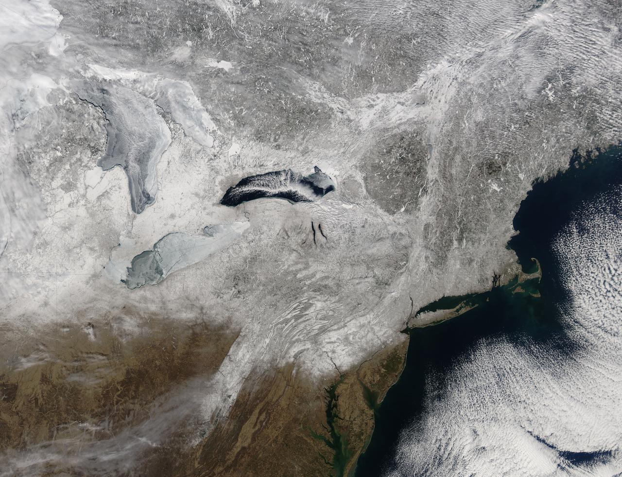 Snow covered the northeastern United States on last day of meteorological winter, 2014. Climatologists and meteorologists break seasons down into three-month groups, based on annual temperature and our calendar. This method is helpful for weather observing and forecasting, and for planning consistent agricultural dates, such as expected first frosts or best planting date. Meteorological winter – the season where temperatures are, on average, coldest and when snow is most likely to fall – runs from December 1 to February 28 in the United States and Canada.  Winter can also be defined by the astronomical calendar, which is based on the rotation of the Earth around the sun. In this method, the seasons are defined by two solstices (times when the sun’s path is furthest from the Earth’s equator) and two equinoxes (the times when the sun passes directly above the equator). In the Northern Hemisphere, winter begins on the winter solstice, which falls on or around December 22 and ends on or around March 21, at the vernal (spring) equinox.  On February 28, 2014, the Moderate Resolution Imaging Spectroradiometer aboard NASA’s Aqua satellite captured this true-color image of a sunny winter day in the northeastern United States. Snow stretches from Maine west to Indiana and south along the ridges of the Appalachian Mountains well into West Virginia. In Canada, the landscape appears greener, primarily because snow lies on conifers (evergreen) trees in the boreal forest regions. The Great Lakes, with the exception of Lake Ontario, are almost completely covered with ice.  Credit: NASA/GSFC/Jeff Schmaltz/MODIS Land Rapid Response Team   <b><a href="http://www.nasa.gov/audience/formedia/features/MP_Photo_Guidelines.html" rel="nofollow">NASA image use policy.</a></b>  <b><a href="http://www.nasa.gov/centers/goddard/home/index.html" rel="nofollow">NASA Goddard Space Flight Center</a></b> enables NASA’s mission through four scientific endeavors: Earth Science, Heliophysics, Solar System Exploration, and Astrophysics. Goddard plays a leading role in NASA’s accomplishments by contributing compelling scientific knowledge to advance the Agency’s mission.  <b>Follow us on <a href="http://twitter.com/NASAGoddardPix" rel="nofollow">Twitter</a></b>  <b>Like us on <a href="http://www.facebook.com/pages/Greenbelt-MD/NASA-Goddard/395013845897?ref=tsd" rel="nofollow">Facebook</a></b>  <b>Find us on <a href="http://instagram.com/nasagoddard?vm=grid" rel="nofollow">Instagram</a></b>