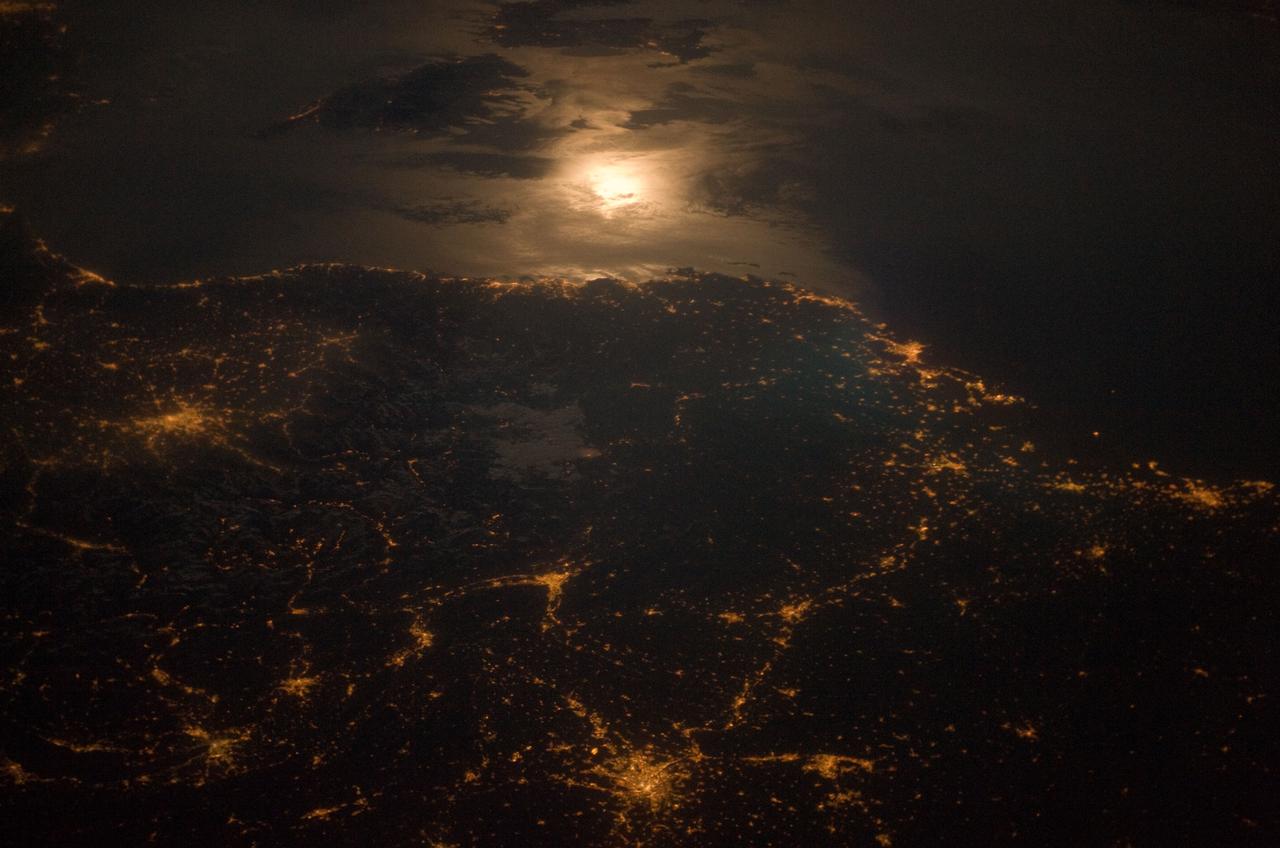 City lights at night along the France-Italy border, Europe are featured in this image photographed by an Expedition 23 crew member on the International Space Station (ISS). The brightly lit metropolitan areas of Torino (Italy), Lyon, and Marseille (both in France) stand out amidst numerous smaller urban areas in this dramatic photograph. The image captures the night time appearance of the France-Italy border area between the mountainous Alps to the north (not shown) and the island of Corsica in the Ligurian Sea to the south (top). The full moon reflects brightly on the water surface and also illuminates the tops of low patchy clouds over the border (center). This image was taken by an ISS crew member at approximately 11:55 p.m. local time when the station was located over the France-Belgium border near Luxembourg. Crew members orbiting Earth frequently collect images that include sunglint, or sunlight that reflects off a water surface at such an angle that it travels directly back towards the observer. Sunglint typically lends a mirror-like appearance to the water surface. During clear sky conditions reflected light from the moon can produce the same effect (moon glint) as illustrated in this view. The observer was looking towards the southeast at an oblique viewing angle at the time the image was taken; in other words, looking outwards from the ISS, not straight down towards Earth. Credit: NASA <b><a href="http://www.nasa.gov/audience/formedia/features/MP_Photo_Guidelines.html" rel="nofollow">NASA image use policy.</a></b> <b><a href="http://www.nasa.gov/centers/goddard/home/index.html" rel="nofollow">NASA Goddard Space Flight Center</a></b> enables NASA’s mission through four scientific endeavors: Earth Science, Heliophysics, Solar System Exploration, and Astrophysics. Goddard plays a leading role in NASA’s accomplishments by contributing compelling scientific knowledge to advance the Agency’s mission. <b>Follow us on <a href="http://twitter.com/NASAGoddardPix" rel="nofollow">Twitter</a></b> <b>Like us on <a href="http://www.facebook.com/pages/Greenbelt-MD/NASA-Goddard/395013845897?ref=tsd" rel="nofollow">Facebook</a></b> <b>Find us on <a href="http://instagram.com/nasagoddard?vm=grid" rel="nofollow">Instagram</a></b>