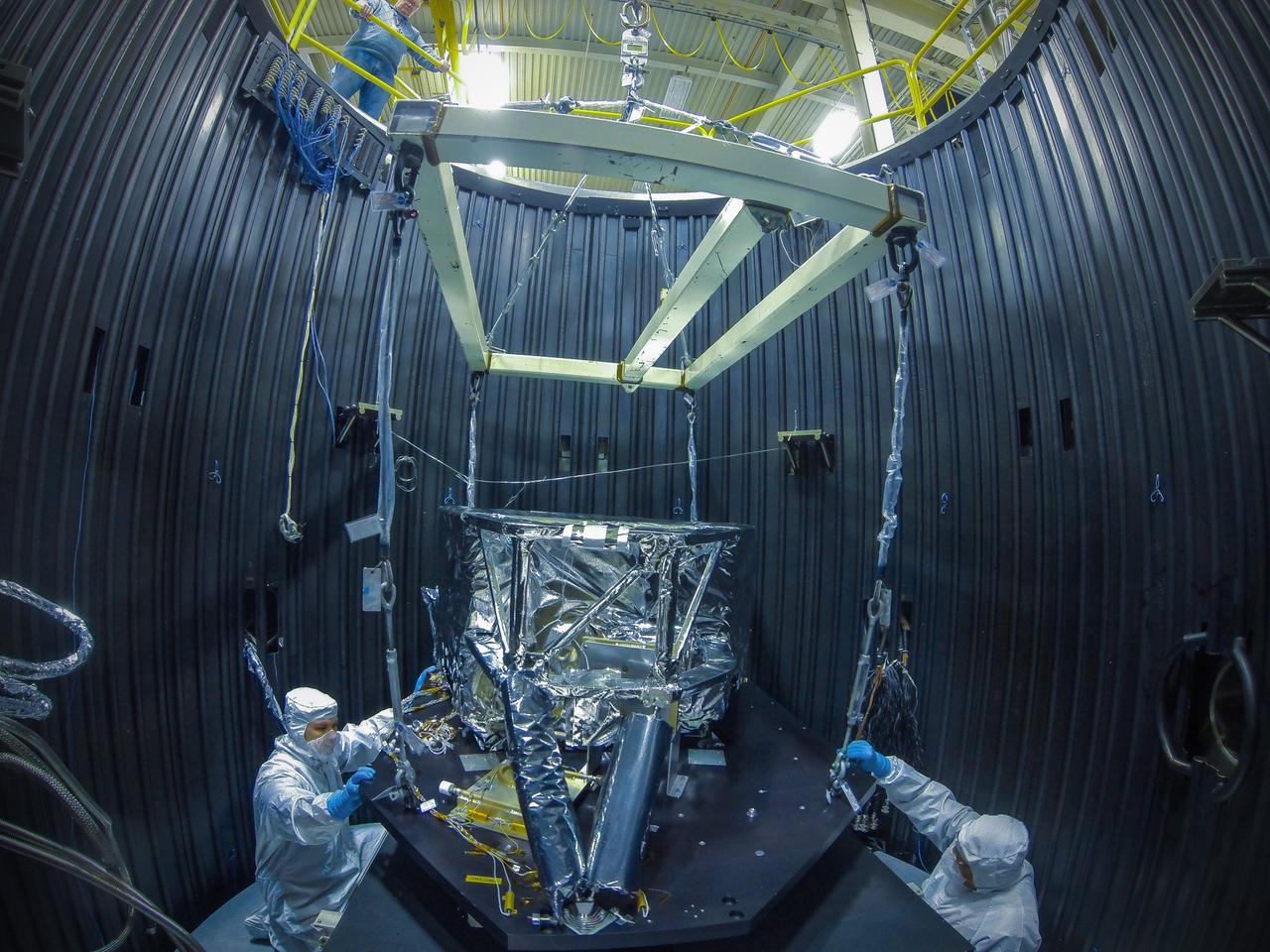 Goddard Technicians Tony Kiem (left) and George Mooney (right) guide the craned structure holding the Webb telescope's Mid-Infrared Instrument or MIRI Shield Environmental Test Unit into place in a cryogenic (cooling) test chamber. This shield will be used to simulate the MIRI instrument during prelaunch testing to verify that the MIRI cooling system will function properly in space. Goddard Safety Engineer Richard Bowlan watches from above.  Image Credit: NASA/Chris Gunn   <b><a href="http://www.nasa.gov/audience/formedia/features/MP_Photo_Guidelines.html" rel="nofollow">NASA image use policy.</a></b>  <b><a href="http://www.nasa.gov/centers/goddard/home/index.html" rel="nofollow">NASA Goddard Space Flight Center</a></b> enables NASA’s mission through four scientific endeavors: Earth Science, Heliophysics, Solar System Exploration, and Astrophysics. Goddard plays a leading role in NASA’s accomplishments by contributing compelling scientific knowledge to advance the Agency’s mission.  <b>Follow us on <a href="http://twitter.com/NASA_GoddardPix" rel="nofollow">Twitter</a></b>  <b>Like us on <a href="http://www.facebook.com/pages/Greenbelt-MD/NASA-Goddard/395013845897?ref=tsd" rel="nofollow">Facebook</a></b>  <b>Find us on <a href="http://instagram.com/nasagoddard?vm=grid" rel="nofollow">Instagram</a></b>