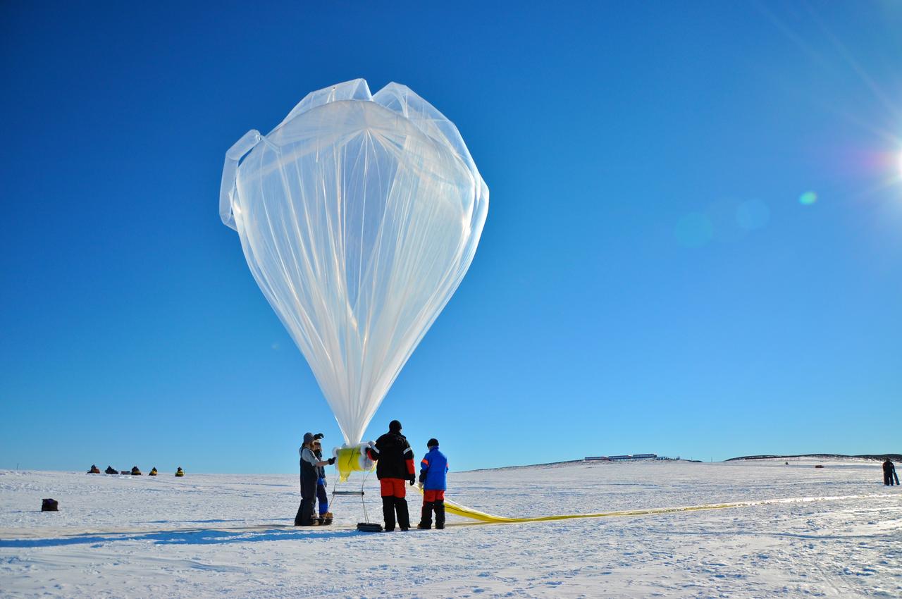 A BARREL balloon floats into the sky as it is partially filled. When fully inflated, each balloon is 90 feet in diameter and carries an instrument suite that weighs 50 pounds. This is small for an Antarctica balloon launch, which can have balloons Typical balloons l the size of a football field with payloads of some 3,000 pounds.    Credit: NASA  ---  In Antarctica in January, 2013 – the summer at the South Pole – scientists launched 20 balloons up into the air to study an enduring mystery of space weather: when the giant radiation belts surrounding Earth lose material, where do the extra particles actually go? The mission is called BARREL (Balloon Array for Radiation belt Relativistic Electron Losses) and it is led by physicist Robyn Millan of Dartmouth College in Hanover, NH. Millan provided photographs from the team’s time in Antarctica.   The team launched a balloon every day or two into the circumpolar winds that circulate around the pole. Each balloon floated for anywhere from 3 to 40 days, measuring X-rays produced by fast-moving electrons high up in the atmosphere. BARREL works hand in hand with another NASA mission called the Van Allen Probes, which travels through the Van Allen radiation belts surrounding Earth. The belts wax and wane over time in response to incoming energy and material from the sun, sometimes intensifying the radiation through which satellites must travel. Scientists wish to understand this process better, and even provide forecasts of this space weather, in order to protect our spacecraft.   As the Van Allen Probes were observing what was happening in the belts, BARREL tracked electrons that precipitated out of the belts and hurtled down Earth’s magnetic field lines toward the poles. By comparing data, scientists will be able to track how what’s happening in the belts correlates to the loss of particles – information that can help us understand this mysterious, dynamic region that can impact spacecraft.   Having launched balloons in early 2013, the team is back at home building the next set of payloads. They will launch 20 more balloons in 2014.    <b><a href="http://www.nasa.gov/audience/formedia/features/MP_Photo_Guidelines.html" rel="nofollow">NASA image use policy.</a></b>  <b><a href="http://www.nasa.gov/centers/goddard/home/index.html" rel="nofollow">NASA Goddard Space Flight Center</a></b> enables NASA’s mission through four scientific endeavors: Earth Science, Heliophysics, Solar System Exploration, and Astrophysics. Goddard plays a leading role in NASA’s accomplishments by contributing compelling scientific knowledge to advance the Agency’s mission.  <b>Follow us on <a href="http://twitter.com/NASA_GoddardPix" rel="nofollow">Twitter</a></b>  <b>Like us on <a href="http://www.facebook.com/pages/Greenbelt-MD/NASA-Goddard/395013845897?ref=tsd" rel="nofollow">Facebook</a></b>  <b>Find us on <a href="http://instagram.com/nasagoddard?vm=grid" rel="nofollow">Instagram</a></b>