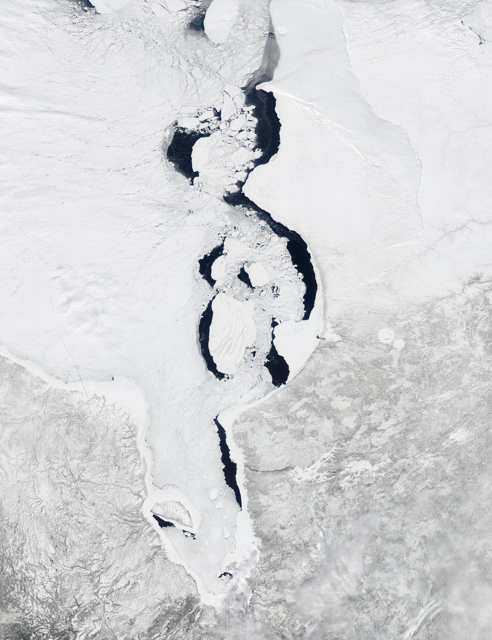 Each winter sea ice forms over the salty waters of frigid northeastern Canada's Hudson Bay. As sunlight lengthens and weather warms, ice begins to break up and melt, with retreat typically starting in May and melt-out completed sometime in July. Since the 1970s, the timing of sea ice breakup in Hudson Bay has changed, with melting beginning earlier in the spring.  The Moderate Resolution Imaging Spectroradiometer (MODIS) aboard NASA’s Aqua satellite captured this a true-color image of Hudson Bay on March 26, 2013. Although snow still covers the surrounding land, ice has already begun to retreat from much of the eastern shore of the Bay visible in the image.  A ring of bright white ice remains solidly frozen around the Belcher Islands in the southeast section of the Bay, but this ring is surrounded by blue waters and large chunks of ice. In the southwest, a similar situation is seen at Akimiski Island. The shelf of bright white ice gives way to open water in the south, as well as fractured, blue-tinted ice. The blue tint generally indicates water logging as ice begins to soften.  The Aqua satellite captured a similar image of early ice melt on Hudson Bay on April 6, 2012. That image can be viewed at: <a href="http://modis.gsfc.nasa.gov/gallery/individual.php?db_date=2012-04-19" rel="nofollow">modis.gsfc.nasa.gov/gallery/individual.php?db_date=2012-0...</a>   <b><a href="http://www.nasa.gov/audience/formedia/features/MP_Photo_Guidelines.html" rel="nofollow">NASA image use policy.</a></b>  <b><a href="http://www.nasa.gov/centers/goddard/home/index.html" rel="nofollow">NASA Goddard Space Flight Center</a></b> enables NASA’s mission through four scientific endeavors: Earth Science, Heliophysics, Solar System Exploration, and Astrophysics. Goddard plays a leading role in NASA’s accomplishments by contributing compelling scientific knowledge to advance the Agency’s mission.  <b>Follow us on <a href="http://twitter.com/NASA_GoddardPix" rel="nofollow">Twitter</a></b>  <b>Like us on <a href="http://www.facebook.com/pages/Greenbelt-MD/NASA-Goddard/395013845897?ref=tsd" rel="nofollow">Facebook</a></b>  <b>Find us on <a href="http://instagram.com/nasagoddard?vm=grid" rel="nofollow">Instagram</a></b>