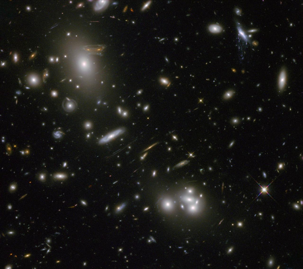 The gravitational field surrounding this massive cluster of galaxies, Abell 68, acts as a natural lens in space to brighten and magnify the light coming from very distant background galaxies.  Like a fun house mirror, lensing creates a fantasy landscape of arc-like images and mirror images of background galaxies. The foreground cluster is 2 billion light-years away, and the lensed images come from galaxies far behind it.  In this photo, the image of a spiral galaxy at upper left has been stretched and mirrored into a shape similar to that of a simulated alien from the classic 1970s computer game &quot;Space Invaders!&quot; A second, less distorted image of the same galaxy appears to the left of the large, bright elliptical galaxy.  In the upper right of the photo is another striking feature of the image that is unrelated to gravitational lensing. What appears to be purple liquid dripping from a galaxy is a phenomenon called ram-pressure stripping. The gas clouds within the galaxy are being stripped out and heated up as the galaxy passes through a region of denser intergalactic gas.  This image was taken in infrared light by Hubble’s Wide Field Camera 3, and combined with near-infrared observations from Hubble’s Advanced Camera for Surveys.  The image is based in part on data spotted by Nick Rose in the Hubble’s Hidden Treasures image processing competition.  The Hubble Space Telescope is a project of international cooperation between NASA and the European Space Agency. NASA's Goddard Space Flight Center in Greenbelt, Md., manages the telescope. The Space Telescope Science Institute (STScI) in Baltimore, Md., conducts Hubble science operations. STScI is operated by the Association of Universities for Research in Astronomy, Inc., in Washington.  Credit: NASA and ESA Acknowledgement: N. Rose  For image files and more information about Abell 68, visit:  <a href="http://hubblesite.org/news/2013/09" rel="nofollow">hubblesite.org/news/2013/09</a> <a href="http://www.spacetelescope.org/news/heic04" rel="nofollow">www.spacetelescope.org/news/heic04</a> <a href="http://heritage.stsci.edu/2013/09" rel="nofollow">heritage.stsci.edu/2013/09</a> <a href="http://www.spacetelescope.org/projects/hiddentreasures/" rel="nofollow">www.spacetelescope.org/projects/hiddentreasures/</a>  <b><a href="http://www.nasa.gov/audience/formedia/features/MP_Photo_Guidelines.html" rel="nofollow">NASA image use policy.</a></b>  <b><a href="http://www.nasa.gov/centers/goddard/home/index.html" rel="nofollow">NASA Goddard Space Flight Center</a></b> enables NASA’s mission through four scientific endeavors: Earth Science, Heliophysics, Solar System Exploration, and Astrophysics. Goddard plays a leading role in NASA’s accomplishments by contributing compelling scientific knowledge to advance the Agency’s mission.  <b>Follow us on <a href="http://twitter.com/NASA_GoddardPix" rel="nofollow">Twitter</a></b>  <b>Like us on <a href="http://www.facebook.com/pages/Greenbelt-MD/NASA-Goddard/395013845897?ref=tsd" rel="nofollow">Facebook</a></b>  <b>Find us on <a href="http://instagram.com/nasagoddard?vm=grid" rel="nofollow">Instagram</a></b>