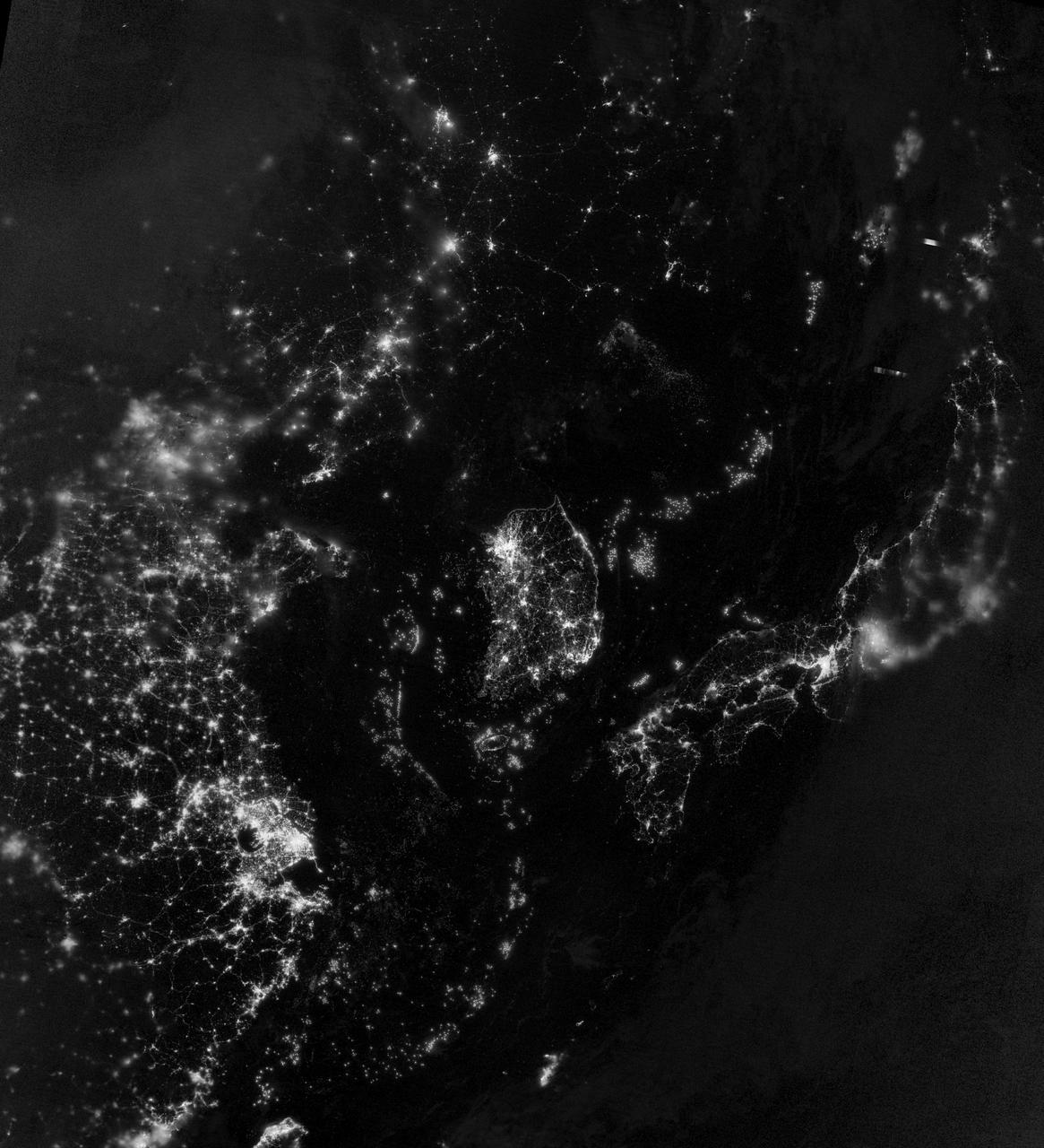 NASA image acquired September 24, 2012 City lights at night are a fairly reliable indicator of where people live. But this isn’t always the case, and the Korean Peninsula shows why. As of July 2012, South Korea’s population was estimated at roughly 49 million people, and North Korea’s population was estimated at about half that number. But where South Korea is gleaming with city lights, North Korea has hardly any lights at all—just a faint glimmer around Pyongyang. On September 24, 2012, the Visible Infrared Imaging Radiometer Suite (VIIRS) on the Suomi NPP satellite captured this nighttime view of the Korean Peninsula. This imagery is from the VIIRS “day-night band,” which detects light in a range of wavelengths from green to near-infrared and uses filtering techniques to observe signals such as gas flares, auroras, wildfires, city lights, and reflected moonlight. The wide-area image shows the Korean Peninsula, parts of China and Japan, the Yellow Sea, and the Sea of Japan. The white inset box encloses an area showing ship lights in the Yellow Sea. Many of the ships form a line, as if assembling along a watery border. Following the 1953 armistice ending the Korean War, per-capita income in South Korea rose to about 17 times the per-capital income level of North Korea, according to the U.S. Central Intelligence Agency. Worldwide, South Korea ranks 12th in electricity production, and 10th in electricity consumption, per 2011 estimates. North Korea ranks 71st in electricity production, and 73rd in electricity consumption, per 2009 estimates. NASA Earth Observatory image by Jesse Allen and Robert Simmon, using VIIRS Day-Night Band data from the Suomi National Polar-orbiting Partnership. Suomi NPP is the result of a partnership between NASA, the National Oceanic and Atmospheric Administration, and the Department of Defense. Caption by Michon Scott. Instrument: Suomi NPP - VIIRS Credit: <b><a href="http://www.earthobservatory.nasa.gov/" rel="nofollow"> NASA Earth Observatory</a></b> <b>Click here to view all of the <a href="http://earthobservatory.nasa.gov/Features/NightLights/" rel="nofollow"> Earth at Night 2012 images </a></b> <b>Click here to <a href="http://earthobservatory.nasa.gov/NaturalHazards/view.php?id=79796" rel="nofollow"> read more </a> about this image </b> <b><a href="http://www.nasa.gov/audience/formedia/features/MP_Photo_Guidelines.html" rel="nofollow">NASA image use policy.</a></b> <b><a href="http://www.nasa.gov/centers/goddard/home/index.html" rel="nofollow">NASA Goddard Space Flight Center</a></b> enables NASA’s mission through four scientific endeavors: Earth Science, Heliophysics, Solar System Exploration, and Astrophysics. Goddard plays a leading role in NASA’s accomplishments by contributing compelling scientific knowledge to advance the Agency’s mission. <b>Follow us on <a href="http://twitter.com/NASA_GoddardPix" rel="nofollow">Twitter</a></b> <b>Like us on <a href="http://www.facebook.com/pages/Greenbelt-MD/NASA-Goddard/395013845897?ref=tsd" rel="nofollow">Facebook</a></b> <b>Find us on <a href="http://instagram.com/nasagoddard?vm=grid" rel="nofollow">Instagram</a></b>