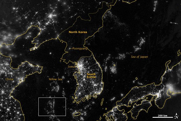 NASA image acquired September 24, 2012  City lights at night are a fairly reliable indicator of where people live. But this isn’t always the case, and the Korean Peninsula shows why. As of July 2012, South Korea’s population was estimated at roughly 49 million people, and North Korea’s population was estimated at about half that number. But where South Korea is gleaming with city lights, North Korea has hardly any lights at all—just a faint glimmer around Pyongyang.  On September 24, 2012, the Visible Infrared Imaging Radiometer Suite (VIIRS) on the Suomi NPP satellite captured this nighttime view of the Korean Peninsula. This imagery is from the VIIRS “day-night band,” which detects light in a range of wavelengths from green to near-infrared and uses filtering techniques to observe signals such as gas flares, auroras, wildfires, city lights, and reflected moonlight.  The wide-area image shows the Korean Peninsula, parts of China and Japan, the Yellow Sea, and the Sea of Japan. The white inset box encloses an area showing ship lights in the Yellow Sea. Many of the ships form a line, as if assembling along a watery border.  Following the 1953 armistice ending the Korean War, per-capita income in South Korea rose to about 17 times the per-capital income level of North Korea, according to the U.S. Central Intelligence Agency. Worldwide, South Korea ranks 12th in electricity production, and 10th in electricity consumption, per 2011 estimates. North Korea ranks 71st in electricity production, and 73rd in electricity consumption, per 2009 estimates.  NASA Earth Observatory image by Jesse Allen and Robert Simmon, using VIIRS Day-Night Band data from the Suomi National Polar-orbiting Partnership. Suomi NPP is the result of a partnership between NASA, the National Oceanic and Atmospheric Administration, and the Department of Defense. Caption by Michon Scott.  Instrument: Suomi NPP - VIIRS   Credit: <b><a href="http://www.earthobservatory.nasa.gov/" rel="nofollow"> NASA Earth Observatory</a></b>  <b>Click here to view all of the <a href="http://earthobservatory.nasa.gov/Features/NightLights/" rel="nofollow"> Earth at Night 2012 images </a></b>  <b>Click here to <a href="http://earthobservatory.nasa.gov/NaturalHazards/view.php?id=79796" rel="nofollow"> read more </a> about this image </b>   <b><a href="http://www.nasa.gov/audience/formedia/features/MP_Photo_Guidelines.html" rel="nofollow">NASA image use policy.</a></b>  <b><a href="http://www.nasa.gov/centers/goddard/home/index.html" rel="nofollow">NASA Goddard Space Flight Center</a></b> enables NASA’s mission through four scientific endeavors: Earth Science, Heliophysics, Solar System Exploration, and Astrophysics. Goddard plays a leading role in NASA’s accomplishments by contributing compelling scientific knowledge to advance the Agency’s mission.  <b>Follow us on <a href="http://twitter.com/NASA_GoddardPix" rel="nofollow">Twitter</a></b>  <b>Like us on <a href="http://www.facebook.com/pages/Greenbelt-MD/NASA-Goddard/395013845897?ref=tsd" rel="nofollow">Facebook</a></b>  <b>Find us on <a href="http://instagram.com/nasagoddard?vm=grid" rel="nofollow">Instagram</a></b>