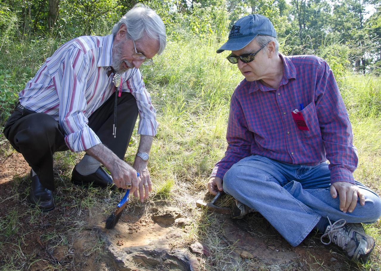 Dinosaur tracker Ray Stanford describes the cretaceous-era nodosaur track he found on the Goddard Space Flight Center campus with Dr. Robert  Weems, emeritus paleontologist for the USGS who verified his discovery.  This imprint shows the right rear foot of a nodosaur - a low-slung, spiny leaf-eater - apparently moving in haste as the heel did not fully settle in the cretaceous mud, according to dinosaur tracker Ray Stanford. It was found recently on NASA's Goddard Space Flight Center campus and is being preserved for study.   To read more go to: <a href="http://1.usa.gov/P9NYg7" rel="nofollow">1.usa.gov/P9NYg7</a>  Credit: NASA/GSFC/Rebecca Roth  <b><a href="http://www.nasa.gov/audience/formedia/features/MP_Photo_Guidelines.html" rel="nofollow">NASA image use policy.</a></b>  <b><a href="http://www.nasa.gov/centers/goddard/home/index.html" rel="nofollow">NASA Goddard Space Flight Center</a></b> enables NASA’s mission through four scientific endeavors: Earth Science, Heliophysics, Solar System Exploration, and Astrophysics. Goddard plays a leading role in NASA’s accomplishments by contributing compelling scientific knowledge to advance the Agency’s mission.  <b>Follow us on <a href="http://twitter.com/NASA_GoddardPix" rel="nofollow">Twitter</a></b>  <b>Like us on <a href="http://www.facebook.com/pages/Greenbelt-MD/NASA-Goddard/395013845897?ref=tsd" rel="nofollow">Facebook</a></b>  <b>Find us on <a href="http://instagrid.me/nasagoddard/?vm=grid" rel="nofollow">Instagram</a></b>