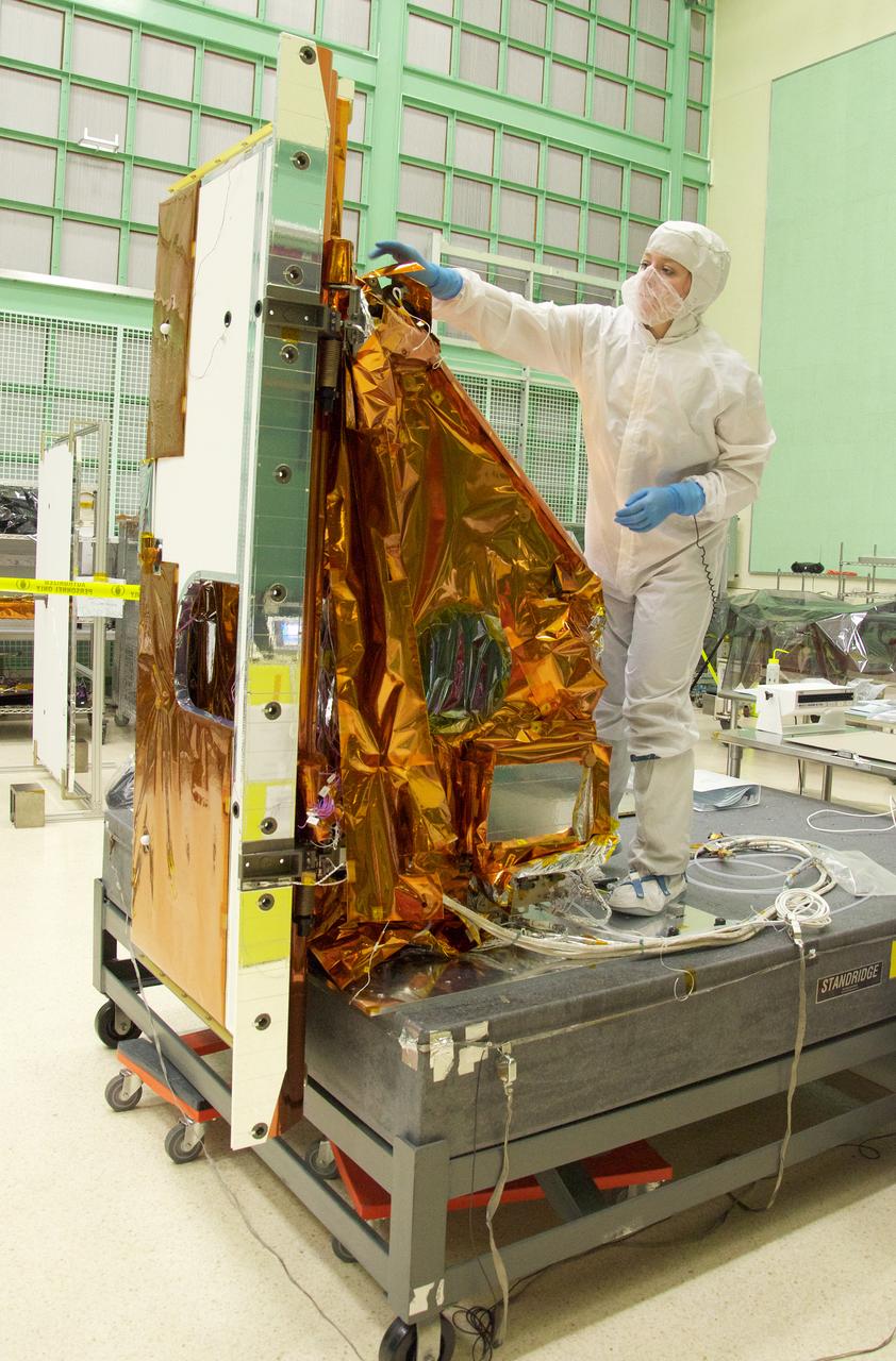 Aleksandra Bogunovic reaches across the instrument to affix the corners of a Multi-Layer Insulation blanket to the TIRS instrument.  The Thermal Infrared Sensor (TIRS) will fly on the next Landsat satellite, the Landsat Data Continuity Mission (LDCM).  TIRS was built on an accelerated schedule at NASA's Goddard Space Flight Center, Greenbelt, Md. and will now be integrated into the LDCM spacecraft at Orbital Science Corp. in Gilbert, Ariz.   The Landsat Program is a series of Earth observing satellite missions jointly managed by NASA and the U.S. Geological Survey. Landsat satellites have been consistently gathering data about our planet since 1972. They continue to improve and expand this unparalleled record of Earth's changing landscapes for the benefit of all.  For more information on Landsat, visit:  <a href="http://www.nasa.gov/landsat" rel="nofollow">www.nasa.gov/landsat</a>  Credit: NASA/GSFC/Rebecca Roth  <b><a href="http://www.nasa.gov/audience/formedia/features/MP_Photo_Guidelines.html" rel="nofollow">NASA image use policy.</a></b>  <b><a href="http://www.nasa.gov/centers/goddard/home/index.html" rel="nofollow">NASA Goddard Space Flight Center</a></b> enables NASA’s mission through four scientific endeavors: Earth Science, Heliophysics, Solar System Exploration, and Astrophysics. Goddard plays a leading role in NASA’s accomplishments by contributing compelling scientific knowledge to advance the Agency’s mission.  <b>Follow us on <a href="http://twitter.com/NASA_GoddardPix" rel="nofollow">Twitter</a></b>  <b>Like us on <a href="http://www.facebook.com/pages/Greenbelt-MD/NASA-Goddard/395013845897?ref=tsd" rel="nofollow">Facebook</a></b>  <b>Find us on <a href="http://instagrid.me/nasagoddard/?vm=grid" rel="nofollow">Instagram</a></b>