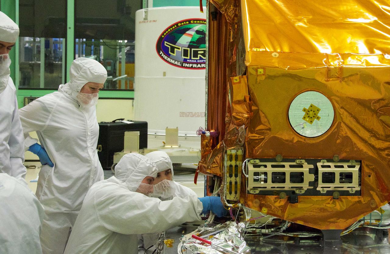 Aleksandra Bogunovic (left) and Veronica Otero (right) look on while Pete Steigner (in the middle) adds a flow tube that will make sure that nitrogen gas flows through the instrument while it's being shipped. The gas will keep contaminating particles from infiltrating the instrument.  The Thermal Infrared Sensor (TIRS) will fly on the next Landsat satellite, the Landsat Data Continuity Mission (LDCM).  TIRS was built on an accelerated schedule at NASA's Goddard Space Flight Center, Greenbelt, Md. and will now be integrated into the LDCM spacecraft at Orbital Science Corp. in Gilbert, Ariz.   The Landsat Program is a series of Earth observing satellite missions jointly managed by NASA and the U.S. Geological Survey. Landsat satellites have been consistently gathering data about our planet since 1972. They continue to improve and expand this unparalleled record of Earth's changing landscapes for the benefit of all.  For more information on Landsat, visit:  <a href="http://www.nasa.gov/landsat" rel="nofollow">www.nasa.gov/landsat</a>  Credit: NASA/GSFC/Rebecca Roth  <b><a href="http://www.nasa.gov/audience/formedia/features/MP_Photo_Guidelines.html" rel="nofollow">NASA image use policy.</a></b>  <b><a href="http://www.nasa.gov/centers/goddard/home/index.html" rel="nofollow">NASA Goddard Space Flight Center</a></b> enables NASA’s mission through four scientific endeavors: Earth Science, Heliophysics, Solar System Exploration, and Astrophysics. Goddard plays a leading role in NASA’s accomplishments by contributing compelling scientific knowledge to advance the Agency’s mission.  <b>Follow us on <a href="http://twitter.com/NASA_GoddardPix" rel="nofollow">Twitter</a></b>  <b>Like us on <a href="http://www.facebook.com/pages/Greenbelt-MD/NASA-Goddard/395013845897?ref=tsd" rel="nofollow">Facebook</a></b>  <b>Find us on <a href="http://instagrid.me/nasagoddard/?vm=grid" rel="nofollow">Instagram</a></b>