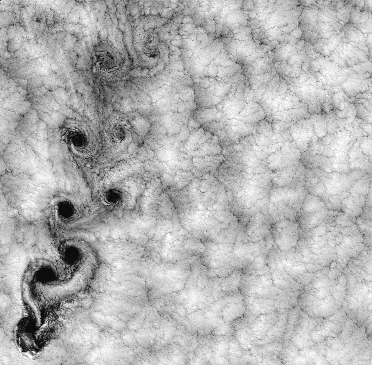 NASA image acquired September 15, 1999  This Landsat 7 image of clouds off the Chilean coast near the Juan Fernandez Islands (also known as the Robinson Crusoe Islands) on September 15, 1999, shows a unique pattern called a “von Karman vortex street.” This pattern has long been studied in the laboratory, where the vortices are created by oil flowing past a cylindrical obstacle, making a string of vortices only several tens of centimeters long. Study of this classic “flow past a circular cylinder” has been very important in the understanding of laminar and turbulent fluid flow that controls a wide variety of phenomena, from the lift under an aircraft wing to Earth’s weather.  Here, the cylinder is replaced by Alejandro Selkirk Island (named after the true “Robinson Crusoe,” who was stranded here for many months in the early 1700s). The island is about 1.5 km in diameter, and rises 1.6 km into a layer of marine stratocumulus clouds. This type of cloud is important for its strong cooling of the Earth’s surface, partially counteracting the Greenhouse warming. An extended, steady equatorward wind creates vortices with clockwise flow off the eastern edge and counterclockwise flow off the western edge of the island. The vortices grow as they advect hundreds of kilometers downwind, making a street 10,000 times longer than those made in the laboratory. Observing the same phenomenon extended over such a wide range of sizes dramatizes the “fractal” nature of atmospheric convection and clouds. Fractals are characteristic of fluid flow and other dynamic systems that exhibit “chaotic” motions.  Both clockwise and counter-clockwise vortices are generated by flow around the island. As the flow separates from the island’s leeward (away from the source of the wind) side, the vortices “swallow” some of the clear air over the island. (Much of the island air is cloudless due to a local “land breeze” circulation set up by the larger heat capacity of the waters surrounding the island.) The “swallowed” gulps of clear island air get carried along within the vortices, but these are soon mixed into the surrounding clouds.  Landsat is unique in its ability to image both the small-scale eddies that mix clear and cloudy air, down to the 30 meter pixel size of Landsat, but also having a wide enough field-of-view, 180 km, to reveal the connection of the turbulence to large-scale flows such as the subtropical oceanic gyres. Landsat 7, with its new onboard digital recorder, has extended this capability away from the few Landsat ground stations to remote areas such as Alejandro Island, and thus is gradually providing a global dynamic picture of evolving human-scale phenomena.  For more details on von Karman vortices, refer to <a href="http://climate.gsfc.nasa.gov/~cahalan" rel="nofollow">climate.gsfc.nasa.gov/~cahalan</a>.  Image and caption courtesy Bob Cahalan, NASA GSFC  Instrument: Landsat 7 - ETM+  Credit: NASA/GSFC/Landsat  <b><a href="http://www.nasa.gov/centers/goddard/home/index.html" rel="nofollow">NASA Goddard Space Flight Center</a></b> enables NASA’s mission through four scientific endeavors: Earth Science, Heliophysics, Solar System Exploration, and Astrophysics. Goddard plays a leading role in NASA’s accomplishments by contributing compelling scientific knowledge to advance the Agency’s mission.  <b>Follow us on <a href="http://twitter.com/NASA_GoddardPix" rel="nofollow">Twitter</a></b>  <b>Join us on <a href="http://www.facebook.com/pages/Greenbelt-MD/NASA-Goddard/395013845897?ref=tsd" rel="nofollow">Facebook</a></b>