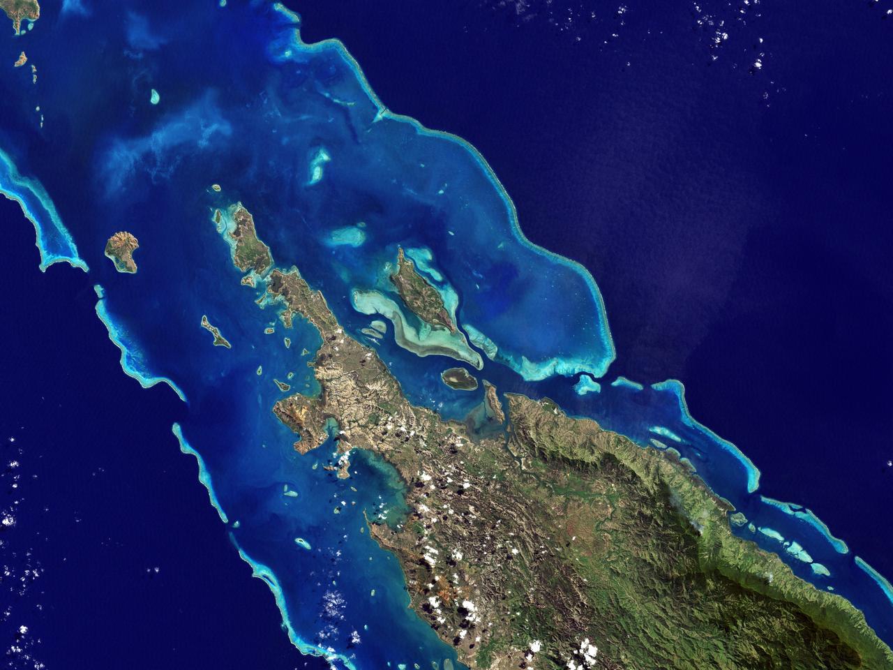 NASA image acquired May 10, 2001  In July 2008, the United Nations Educational, Scientific, and Cultural Organization (UNESCO) added 27 new areas to its list of World Heritage sites. One of those areas included the lagoons of New Caledonia. Some 1,200 kilometers (750 miles) east of Australia, this French-governed archipelago contains the world’s third-largest coral reef structure. The coral reefs enclose the waters near the islands in shallow lagoons of impressive biodiversity.  On May 10, 2001, the Enhanced Thematic Mapper Plus on NASA’s Landsat 7 satellite captured this image of Île Balabio, off the northern tip of Grande Terra, New Caledonia’s main island. In this natural-color image, the islands appear in shades of green and brown—mixtures of vegetation and bare ground. The surrounding waters range in color from pale aquamarine to deep blue, and the color differences result from varying depths. Over coral reef ridges and sand bars, the water is shallowest and palest in color. Darker shades of blue characterize deeper waters. Reef-enclosed, shallow waters surround Île Balabio, and a larger, semi-enclosed lagoon appears immediately east of that island. Immediately north of Grande Terra, unenclosed, deeper waters predominate. The coral reefs around New Caledonia support an unusual diversity of species, including large numbers of predators and big fish, turtles, and the world’s third-largest dugong population.  NASA image created by Jesse Allen, using Landsat data provided by the United States Geological Survey. Caption by Michon Scott.  Instrument: Landsat 7 - ETM+  Credit: NASA/GSFC/Landsat  <b><a href="http://www.nasa.gov/centers/goddard/home/index.html" rel="nofollow">NASA Goddard Space Flight Center</a></b> enables NASA’s mission through four scientific endeavors: Earth Science, Heliophysics, Solar System Exploration, and Astrophysics. Goddard plays a leading role in NASA’s accomplishments by contributing compelling scientific knowledge to advance the Agency’s mission.  <b>Follow us on <a href="http://twitter.com/NASA_GoddardPix" rel="nofollow">Twitter</a></b>  <b>Join us on <a href="http://www.facebook.com/pages/Greenbelt-MD/NASA-Goddard/395013845897?ref=tsd" rel="nofollow">Facebook</a></b>