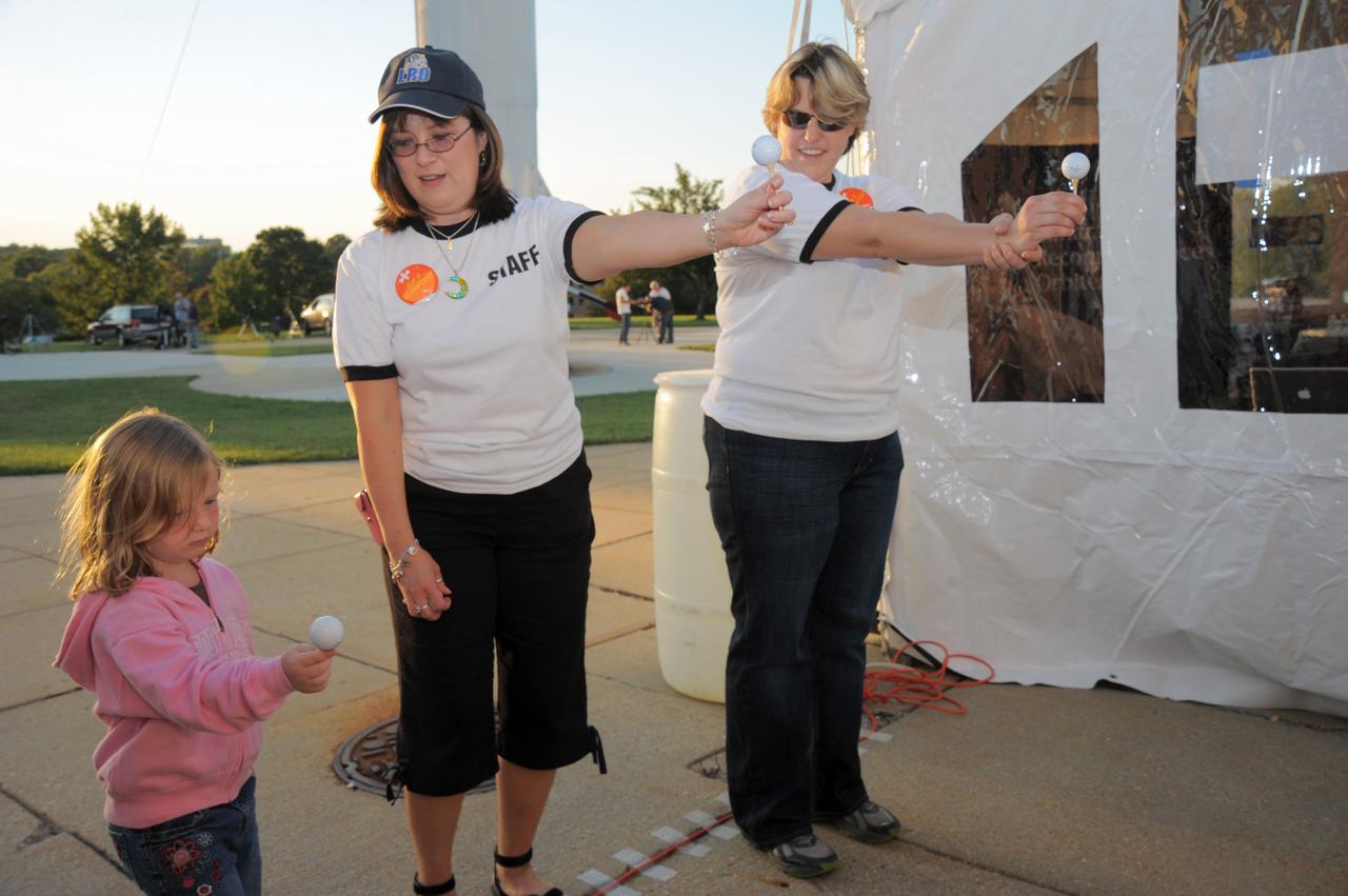 Cathie Peddie - Deputy Project Manager LRO  (center) shows a young visitor shadows demo.   Credit: NASA/GSFC/Debbie Mccallum  On September 18, 2010 the world joined the NASA Goddard Space Flight Center's Visitor Center in Greenbelt, Md., as well as other NASA Centers to celebrate the first annual International Observe the Moon Night (InOMN).  To read more go to: <a href="http://www.nasa.gov/centers/goddard/news/features/2010/moon-night.html" rel="nofollow">www.nasa.gov/centers/goddard/news/features/2010/moon-nigh...</a>  <b><a href="http://www.nasa.gov/centers/goddard/home/index.html" rel="nofollow">NASA Goddard Space Flight Center</a></b>  contributes to NASA’s mission through four scientific endeavors: Earth Science, Heliophysics, Solar System Exploration, and Astrophysics. Goddard plays a leading role in NASA’s endeavors by providing compelling scientific knowledge to advance the Agency’s mission.  <b>Follow us on <a href="http://twitter.com/NASA_GoddardPix" rel="nofollow">Twitter</a></b>  <b>Join us on <a href="http://www.facebook.com/pages/Greenbelt-MD/NASA-Goddard/395013845897?ref=tsd" rel="nofollow">Facebook</a></b>