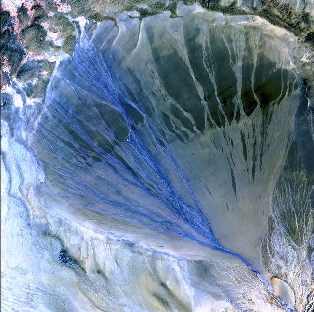 Image taken 5/2/2002 by ASTER: A vast alluvial fan blossoms across the desolate landscape between the Kunlun and Altun mountain ranges that form the southern border of the Taklimakan Desert in China's XinJiang Province.     This image can be found on ASTER Path 143 Row 34, center: 37.43 N, 84.30 E.  To learn more about the Landsat satellite go to:  <a href="http://landsat.gsfc.nasa.gov/" rel="nofollow">landsat.gsfc.nasa.gov/</a>