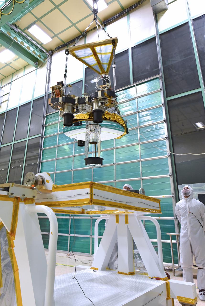 Engineers and technicians from the Global Ecosystem Dynamics Investigation (GEDI) use a crane to lift the Optical Bench during integration activities inside the Spacecraft Checkout and Integraton Area (SCA) clean room at Goddard Space Flight Center