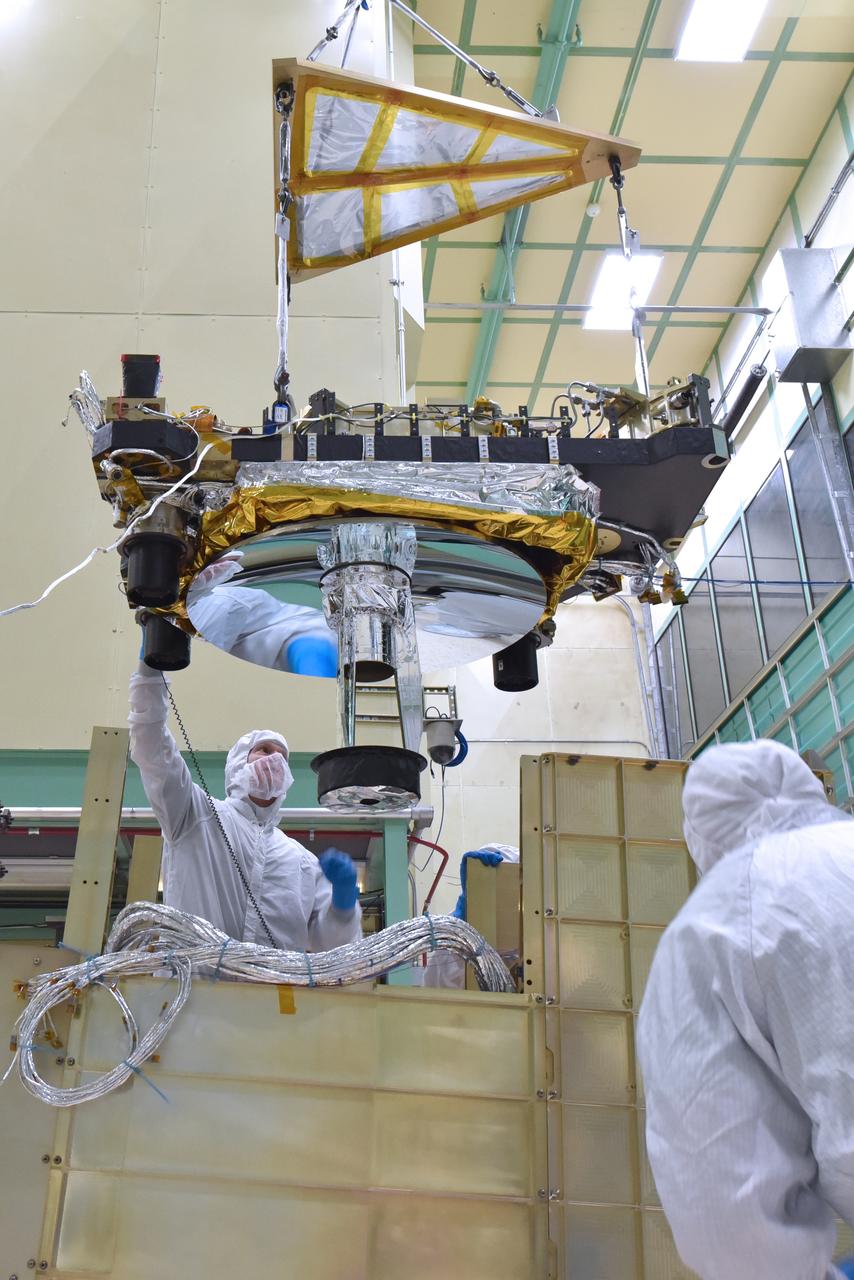 Engineers and technicians from the Global Ecosystem Dynamics Investigation (GEDI) integrate the Optical Bench and the Box Structure in the Spacecraft Checkout and Integration Area (SCA) clean room at Goddard Space Flight Center.