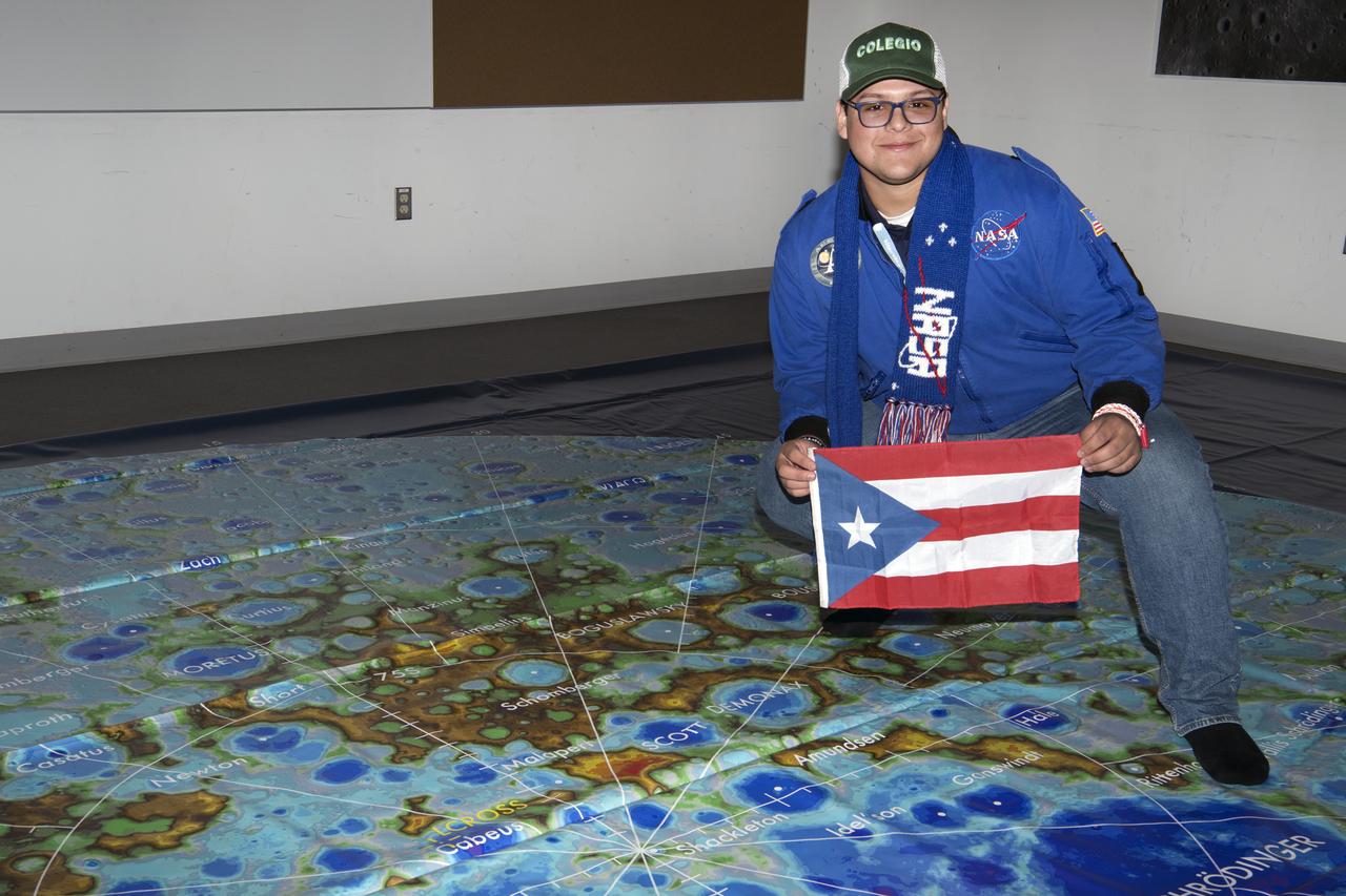 Social media followers visited GSFC Feb 10, 2020 learning role of Artemis, LRO Lunar Reconnaisssance Orbiter, and spoke with science experts while touring center  Here student holds Puerto Rico flag over map  