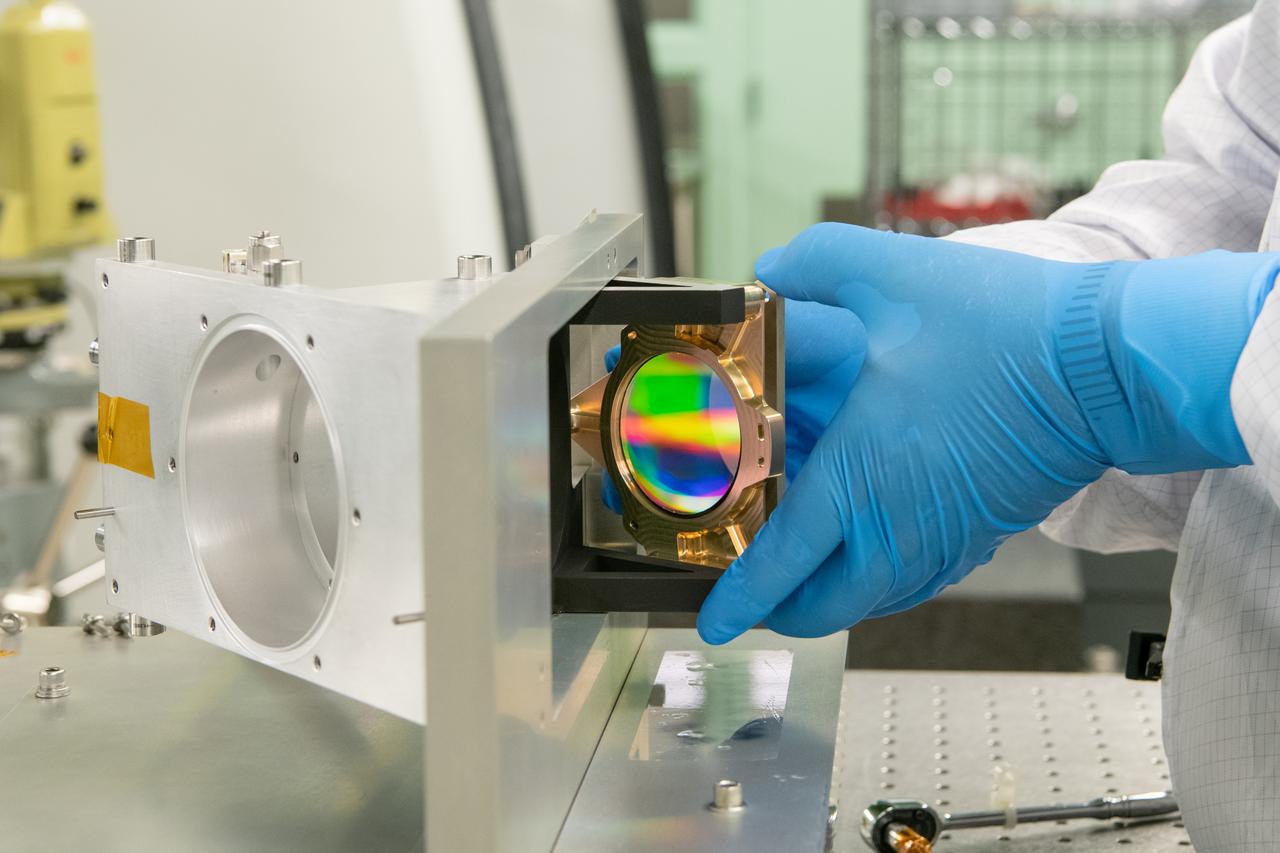 An Ocean Color Instrument (OCI) optical lens is installed into the flight housing hardware for alignment measurements.  OCI is a highly advanced optical spectrometer that will be used to measure properties of light over portions of the electromagnetic spectrum. It will enable continuous measurement of light at finer wavelength resolution than previous NASA satellite sensors, extending key system ocean color data records for climate studies. OCI is PACE's (Plankton, Aerosol, Cloud, ocean Ecosystem) primary sensor built at Goddard Space Flight Center in Greenbelt, MD.