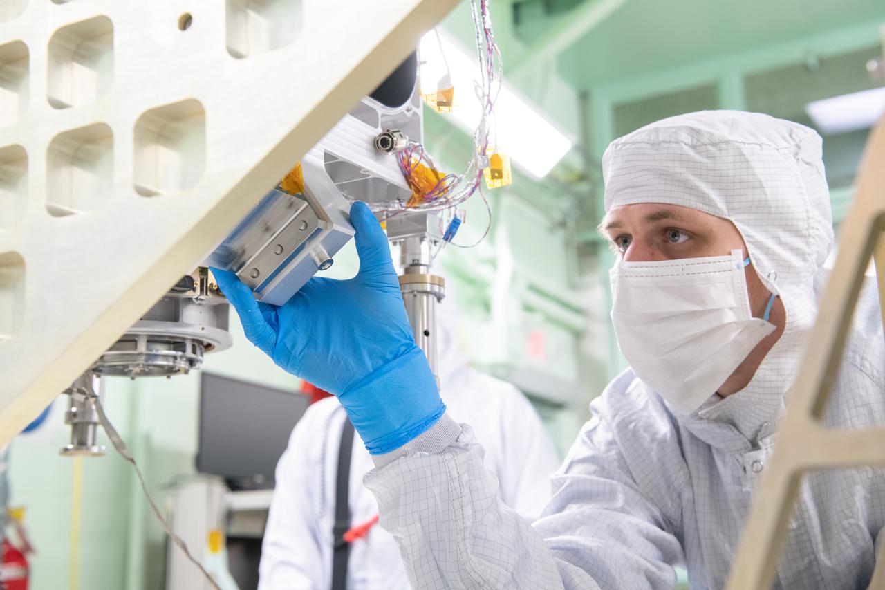 Mechanical technician, Joseph Eddy, carefully guides the Ocean Color Instrument (OCI) Main Optics Bench (MOB) during a crane lift onto its turnover fixture. This fixture allows the team to integrate additional components multiple different orientations.  OCI is a highly advanced optical spectrometer that will be used to measure properties of light over portions of the electromagnetic spectrum. It will enable continuous measurement of light at finer wavelength resolution than previous NASA satellite sensors, extending key system ocean color data records for climate studies. OCI is PACE's (Plankton, Aerosol, Cloud, ocean Ecosystem) primary sensor built at Goddard Space Flight Center in Greenbelt, MD.