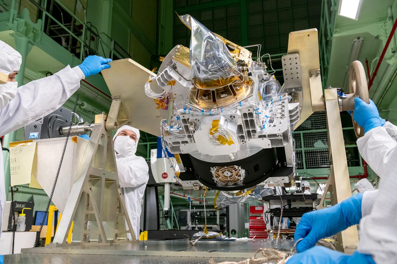 Mechanical technicians reorient the Ocean Color Instrument (OCI) Optical Module on a rotation fixture to allow for additional hardware integration.   OCI is a highly advanced optical spectrometer that will be used to measure properties of light over portions of the electromagnetic spectrum. It will enable continuous measurement of light at finer wavelength resolution than previous NASA satellite sensors, extending key system ocean color data records for climate studies. OCI is PACE's (Plankton, Aerosol, Cloud, ocean Ecosystem) primary sensor built at Goddard Space Flight Center in Greenbelt, MD.