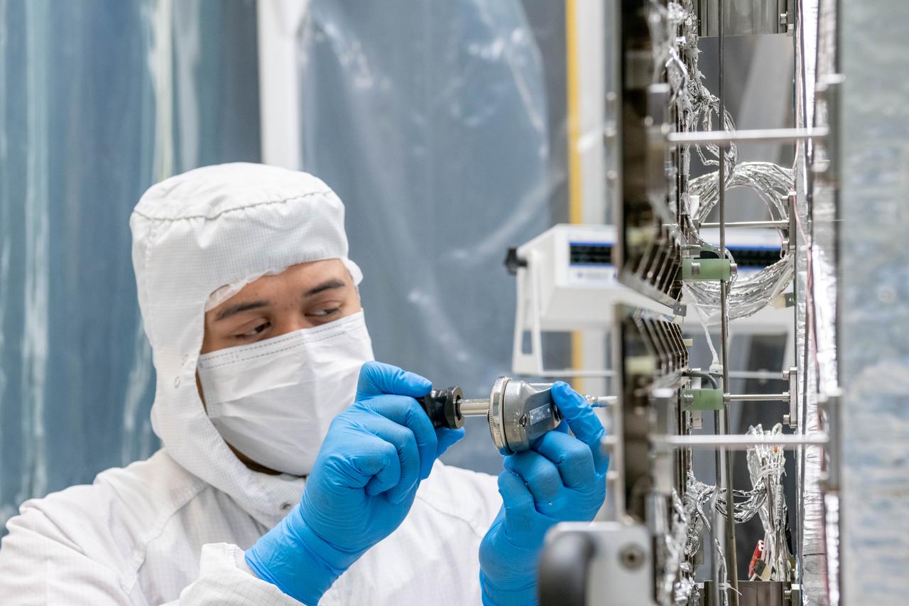Mechanical technician, Dan Dizon, tightens bolts on the loop heat pipe radiator on the Ocean Color Instrument (OCI) in a clean tent where the final hardware of the OCI are installed and tested.  OCI is a highly advanced optical spectrometer that will be used to measure properties of light over portions of the electromagnetic spectrum. It will enable continuous measurement of light at finer wavelength resolution than previous NASA satellite sensors, extending key system ocean color data records for climate studies. OCI is PACE's (Plankton, Aerosol, Cloud, ocean Ecosystem) primary sensor built at Goddard Space Flight Center in Greenbelt, MD.