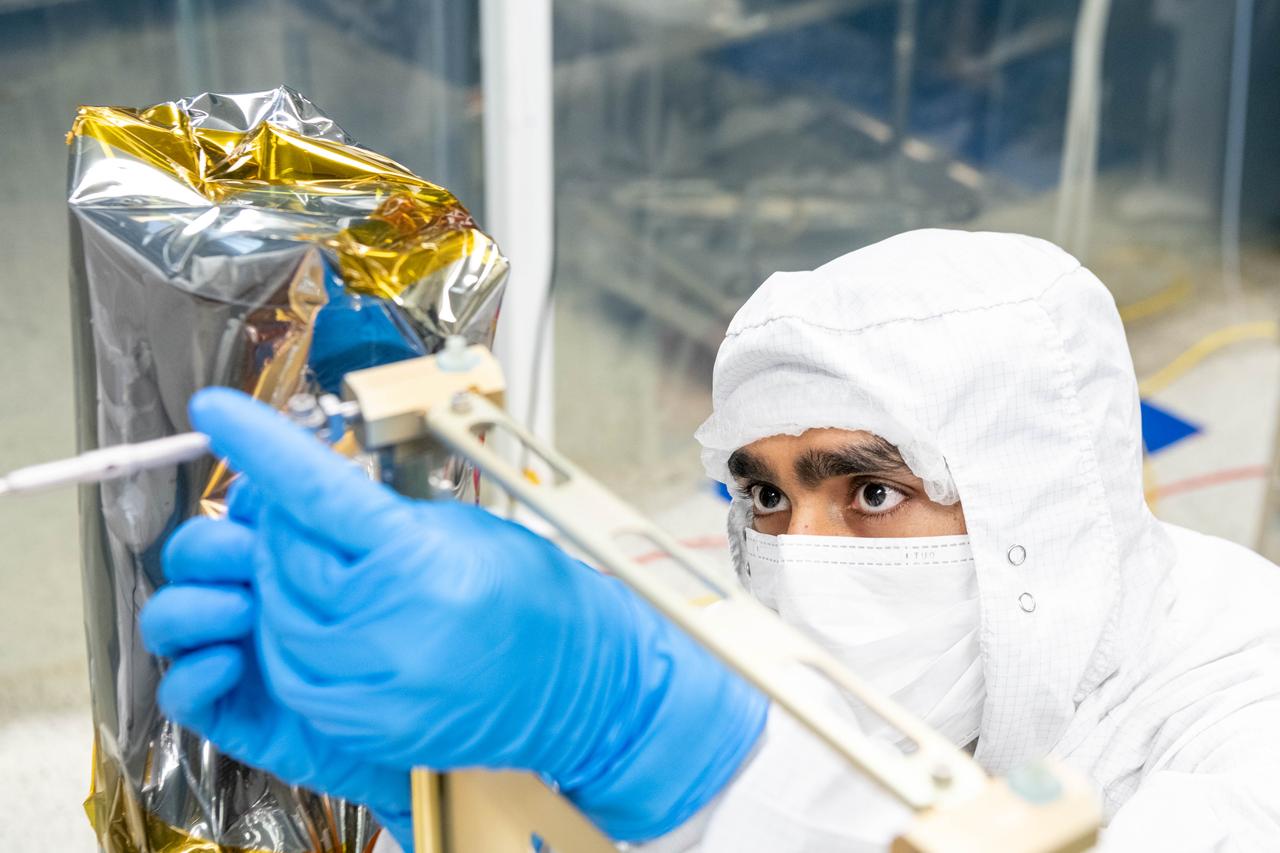 Thermal engineer, Deepak Patel, inspects the tightness on a tensioning cable on the Ocean Color Instrument (OCI). After his inspection, technicians will install thermal blanketing to insulate the flight hardware for further testing.  OCI is a highly advanced optical spectrometer that will be used to measure properties of light over portions of the electromagnetic spectrum. It will enable continuous measurement of light at finer wavelength resolution than previous NASA satellite sensors, extending key system ocean color data records for climate studies. OCI is PACE's (Plankton, Aerosol, Cloud, ocean Ecosystem) primary sensor built at Goddard Space Flight Center in Greenbelt, MD.