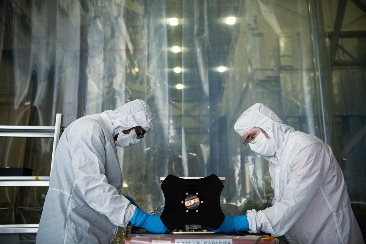 UMBC Earth and Space Institute engineers Yomiyu Fekadu (left) and Danny Nelson (right) prepare the Hyper-Angular Rainbow Polarimeter #2 (HARP2) instrument for thermal vacuum testing at NASA's Goddard Space Flight Center in Greenbelt Maryland on August 8th, 2022.  HARP2 is one of three instruments on NASA's Plankton, Aerosol, Cloud, ocean Ecosystem (PACE) observatory, it was designed and built by UMBC's Earth and Space Institute. 