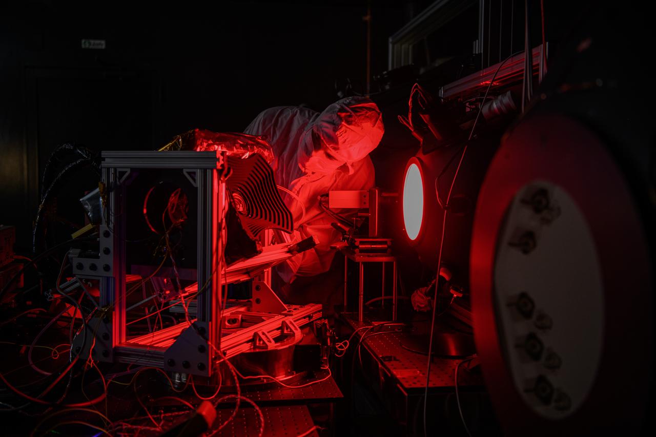 An engineer inspects the The Hyper-Angular Rainbow Polarimeter #2 (HARP2) instrument during calibration testing after at NASA's Goddard Space Flight Center in Greenbelt Maryland on October 4th, 2022.  HARP2 is one of three instruments on NASA's Plankton, Aerosol, Cloud, ocean Ecosystem (PACE) observatory, it was designed and built by UMBC's Earth and Space Institute. 